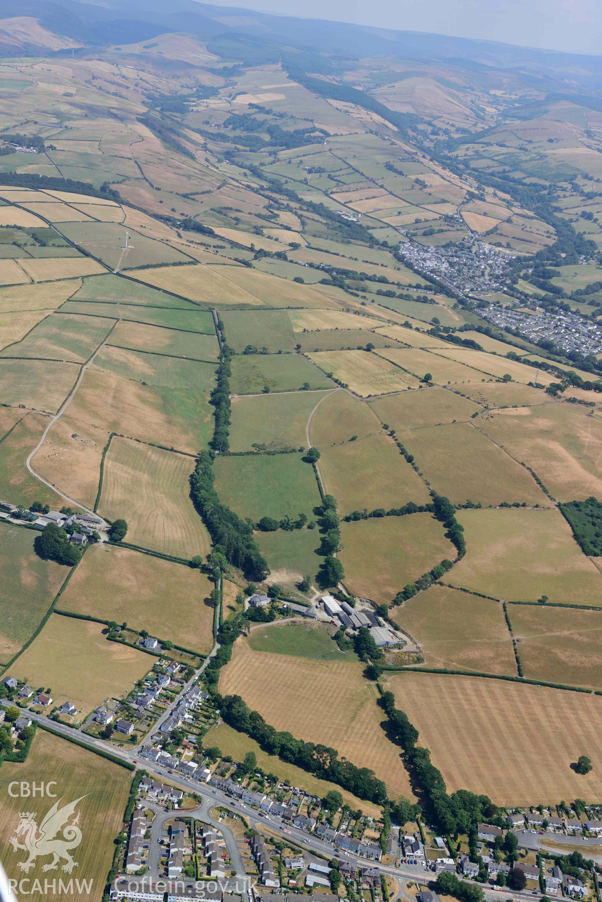 Caergywydd and surrounding landscape. Oblique aerial photograph taken during the Royal Commission’s programme of archaeological aerial reconnaissance by Toby Driver on 10 July 2018.