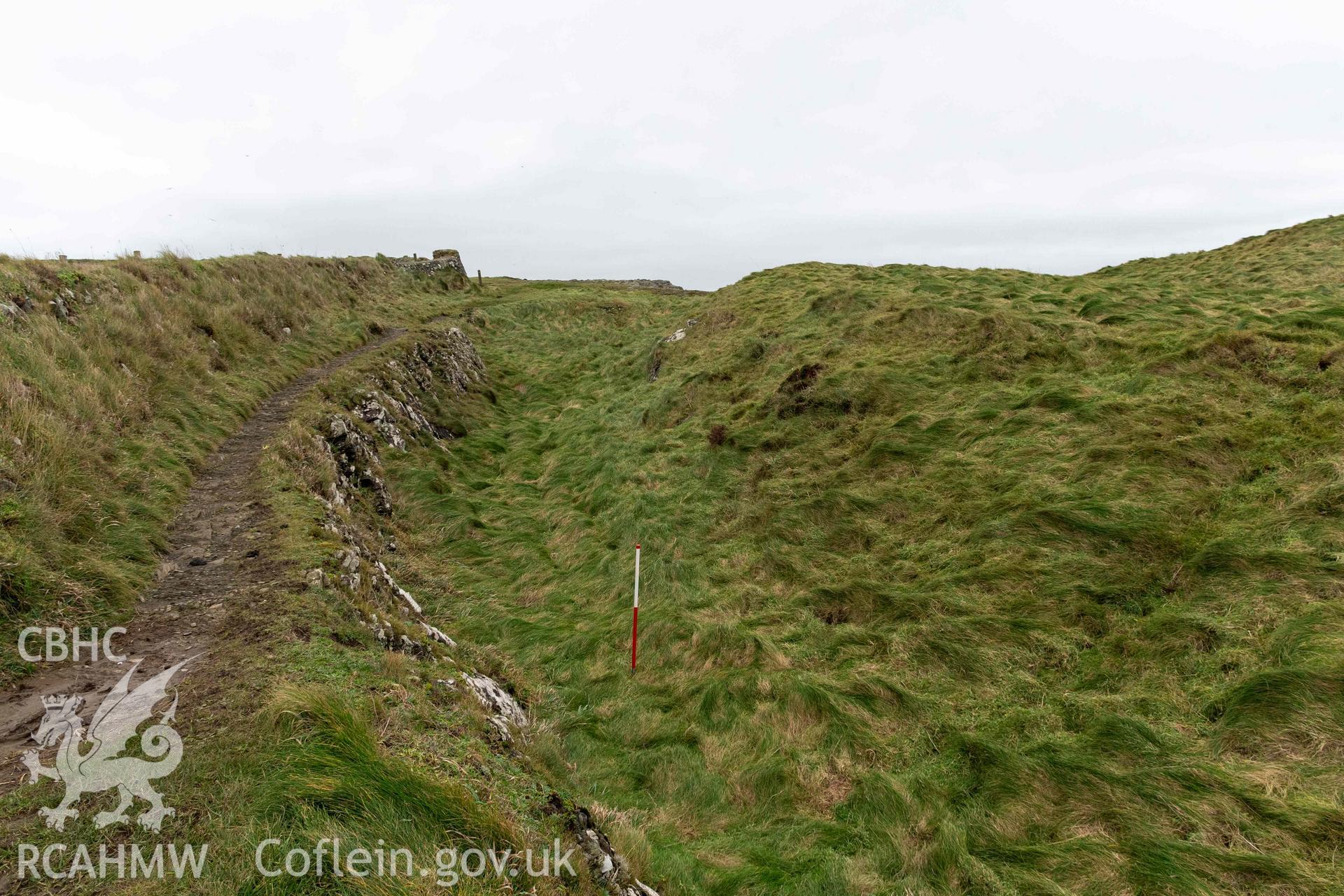 Castell Coch Promontory Fort. Modern wall, outer rock-cut ditch and scarp, looking south (with scale).