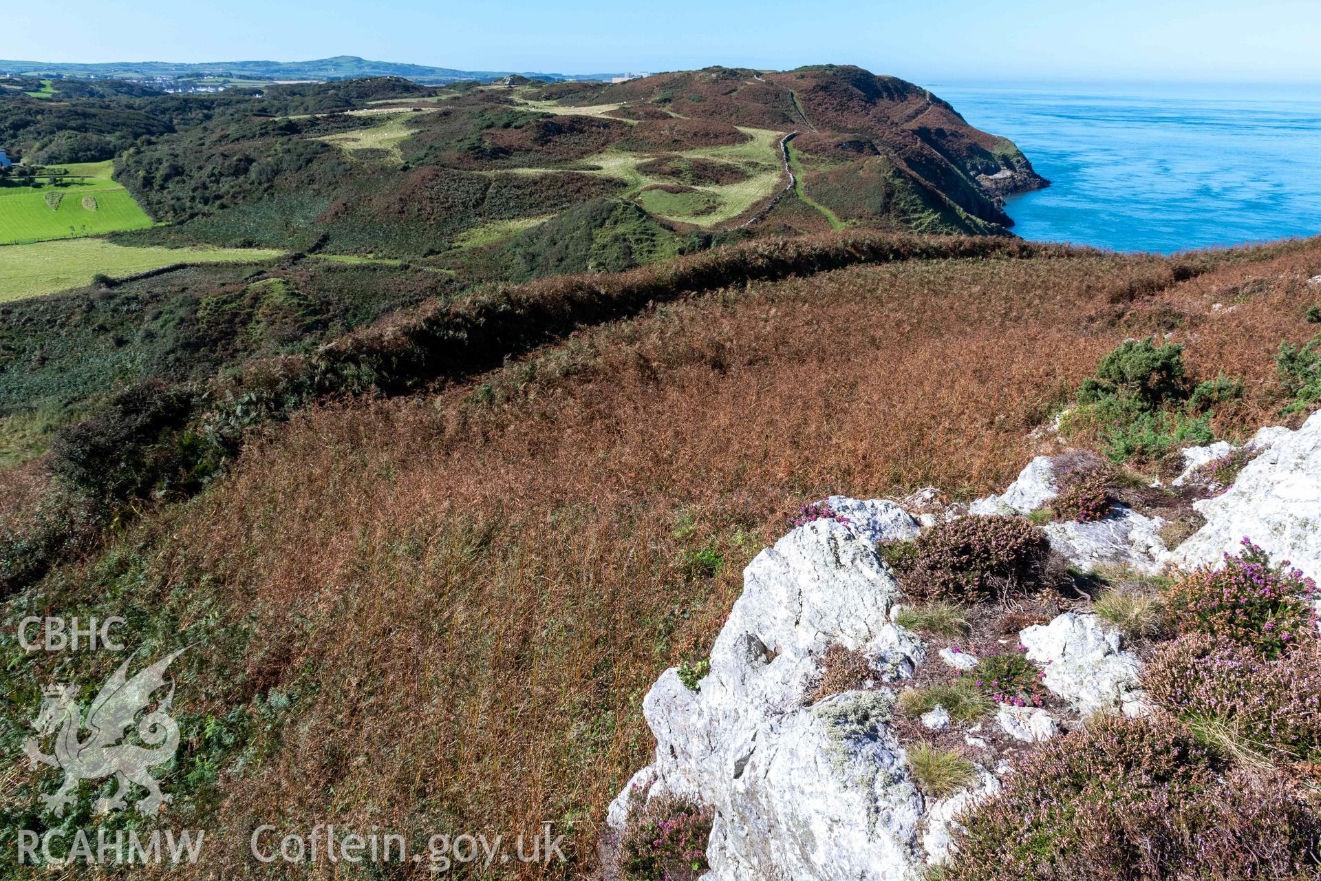 Dinas Gynfor Coastal Hillfort. View from rock outcrops in hillfort interior looking southwest, with a shadow cast along a second line of defenses defining an enclosure against the rock outcrops.