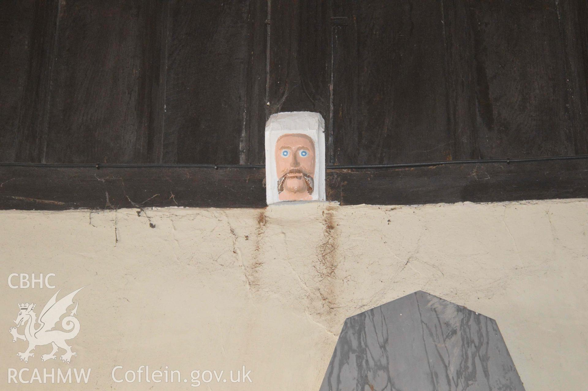 Photograph showing carved mask, one of a number of face carvings, presumed to be of 13-15th century origin, which depict bishops,
kings, the devil or bearded faces crowned with oak-leaves (possibly greenman imagery). From an Archaeological Survey and Watching Brief of St Cynhafal’s Church, Llangynhafal, carried out by Clwyd-Powys Archaeological Trust in 2021. Project no. 2520.