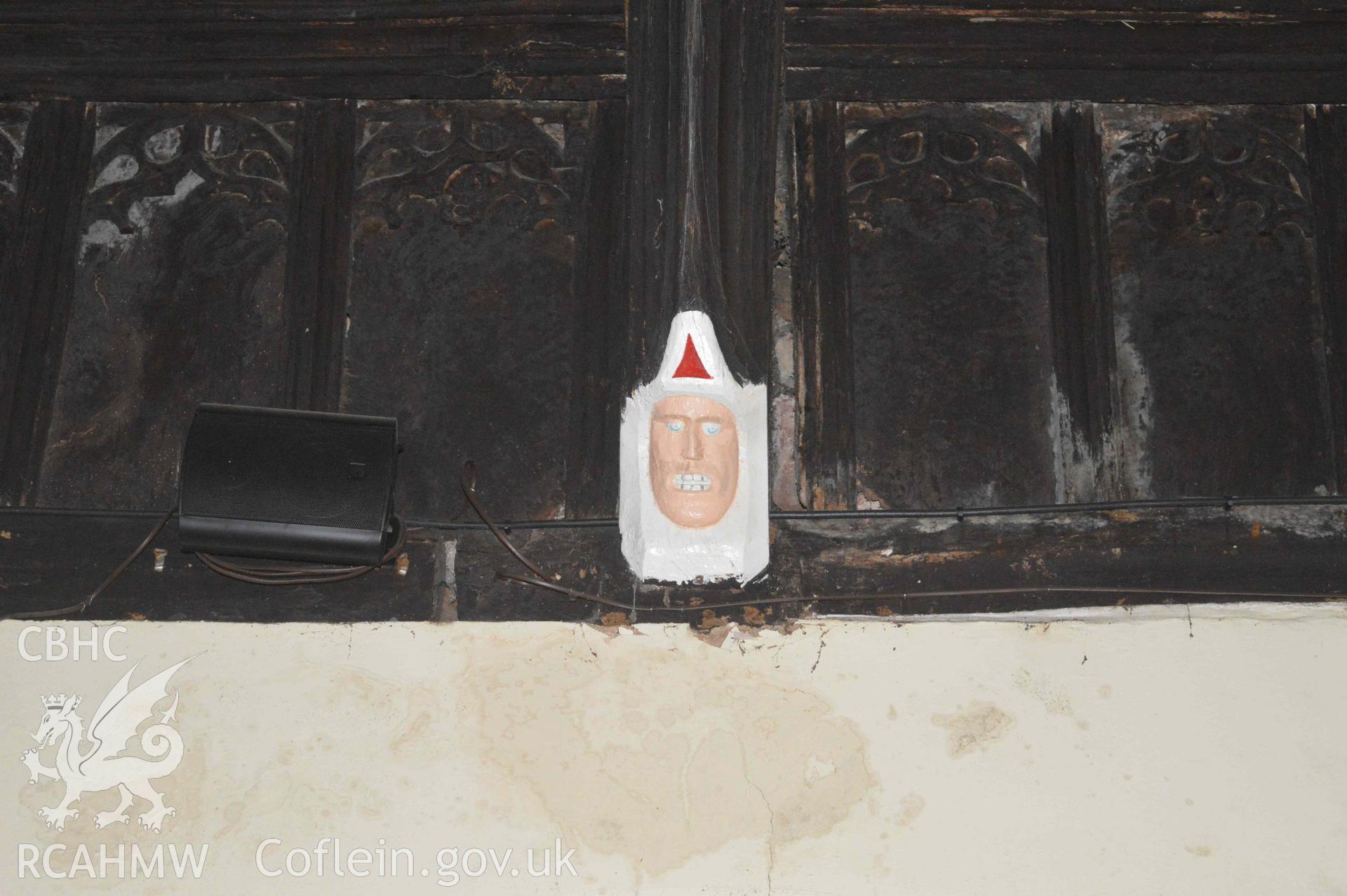 Photograph showing carved mask, one of a number of face carvings, presumed to be of 13-15th century origin, which depict bishops,
kings, the devil or bearded faces crowned with oak-leaves (possibly greenman imagery). From an Archaeological Survey and Watching Brief of St Cynhafal’s Church, Llangynhafal, carried out by Clwyd-Powys Archaeological Trust in 2021. Project no. 2520.