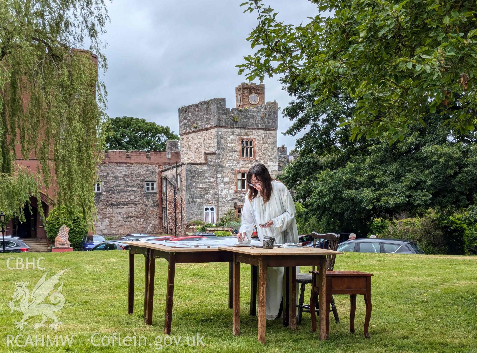 The Ffynogion spoons. Artist Olivia Hicks RA working on a composition based on the spoons at the Ruthin International Arts Festival, June 2024. View showing art performance in grounds of Ruthin Castle