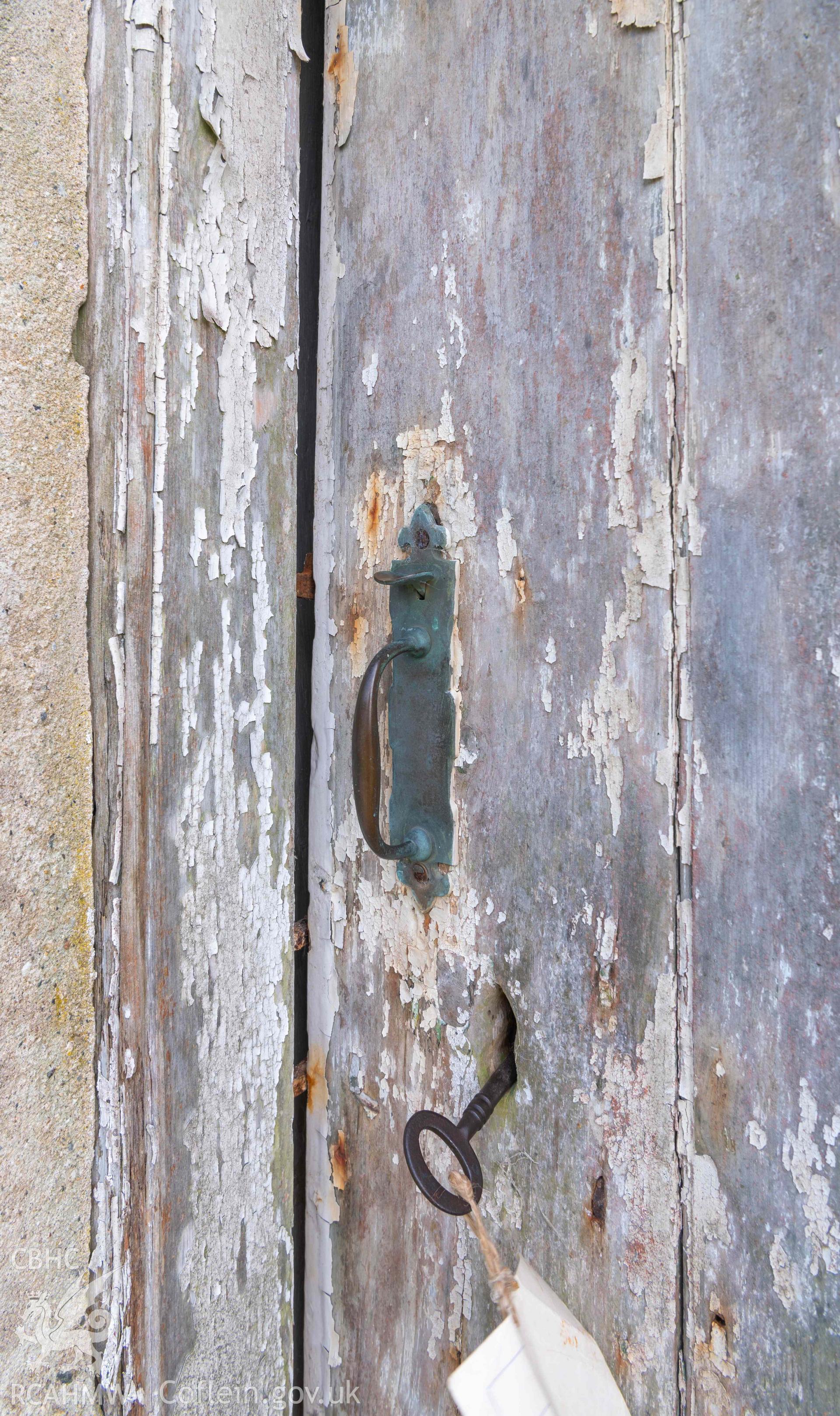 Capel Newydd - Detailed view of the door handle and key in the lock of the East entrance, taken from North