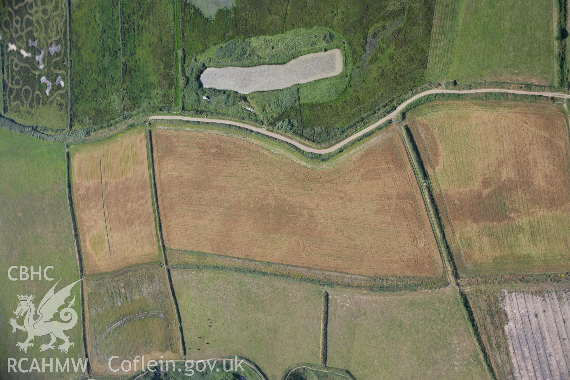 RCAHMW colour oblique aerial photograph of Runwayskiln Prehistoric Settlement Cropmarks. Taken on 24 July 2006 by Toby Driver.