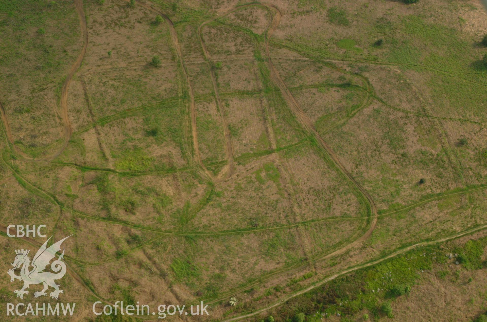 RCAHMW colour oblique aerial photograph of an enclosure and farmstead at Grey Hill. Taken on 26 May 2004 by Toby Driver