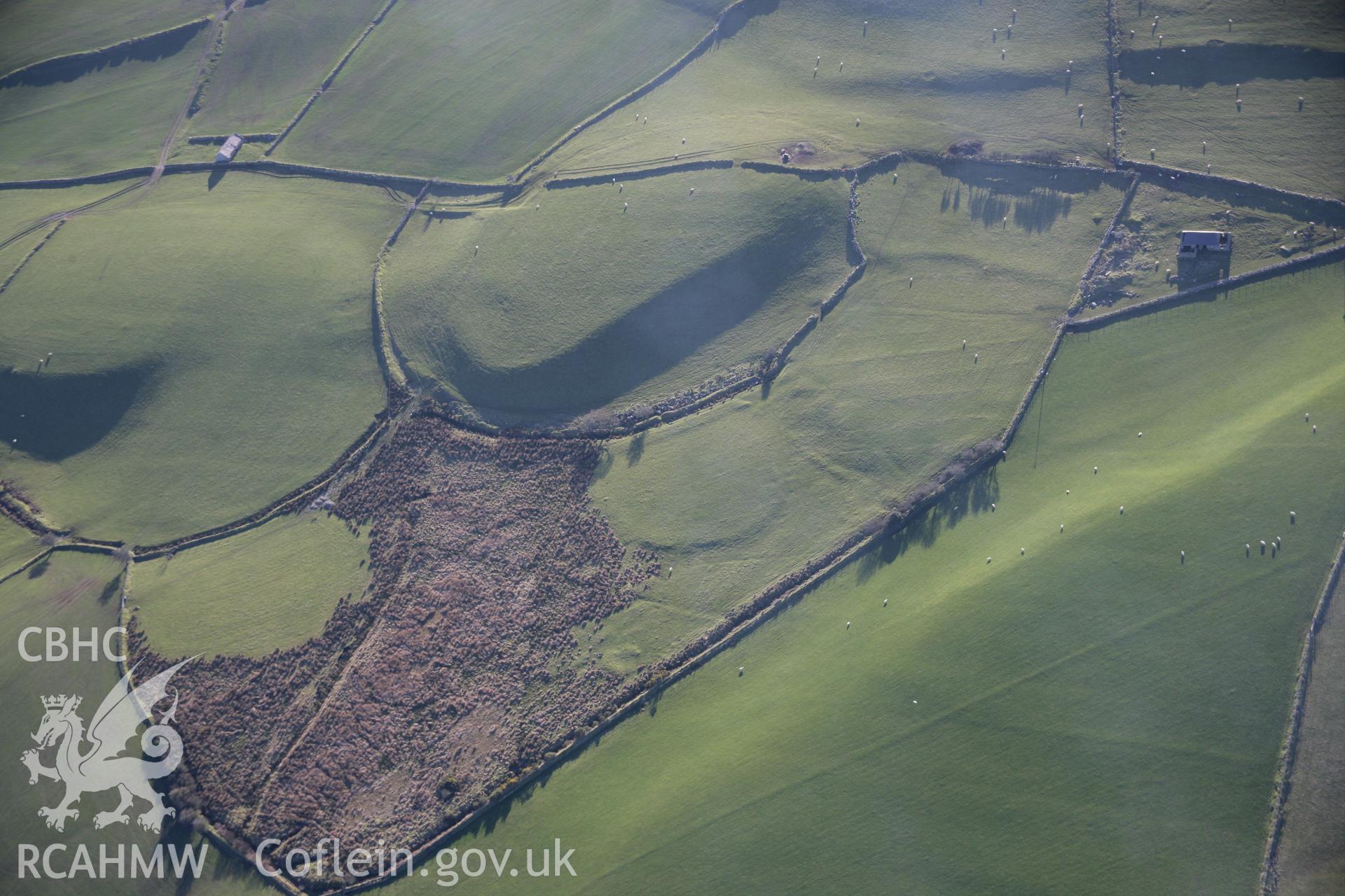 RCAHMW colour oblique aerial photograph of Cae'r-Weirglodd Lynchets from the north-east with an earthwork mound on the edge of the bog. Taken on 09 February 2006 by Toby Driver.