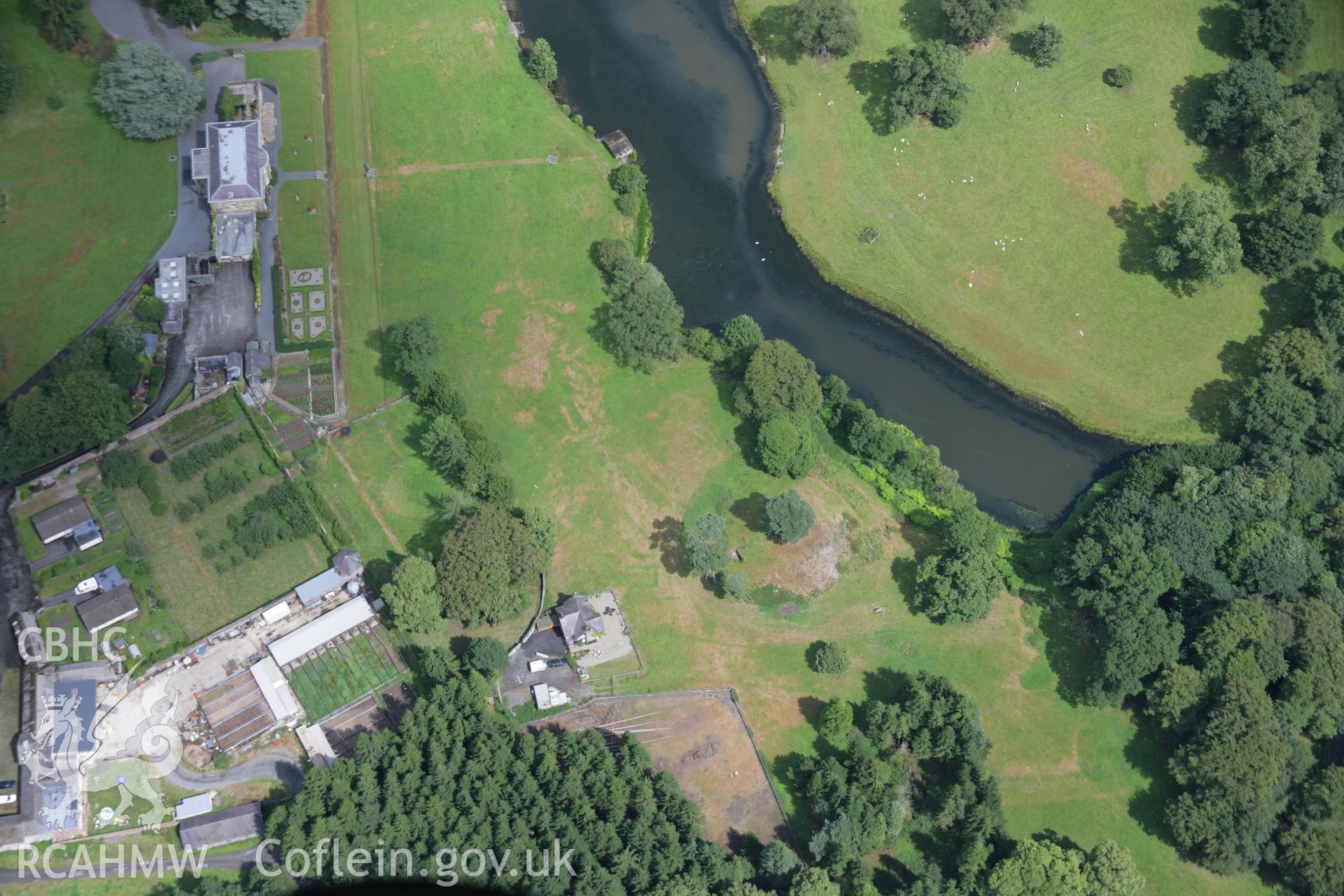 RCAHMW colour oblique aerial photograph of Rug Castle Mound and Prehistoric Funerary Monument with parchmarks showing. Taken on 31 July 2006 by Toby Driver.