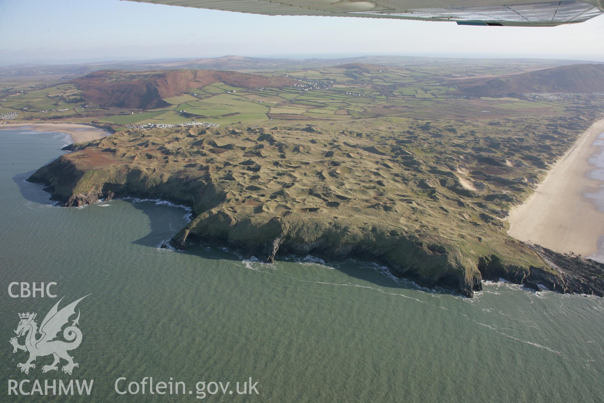 RCAHMW colour oblique aerial photograph of Culver Hole. Viewed from the north-west with Llangennith Burrows visible beyond. Taken on 26 January 2006 by Toby Driver.