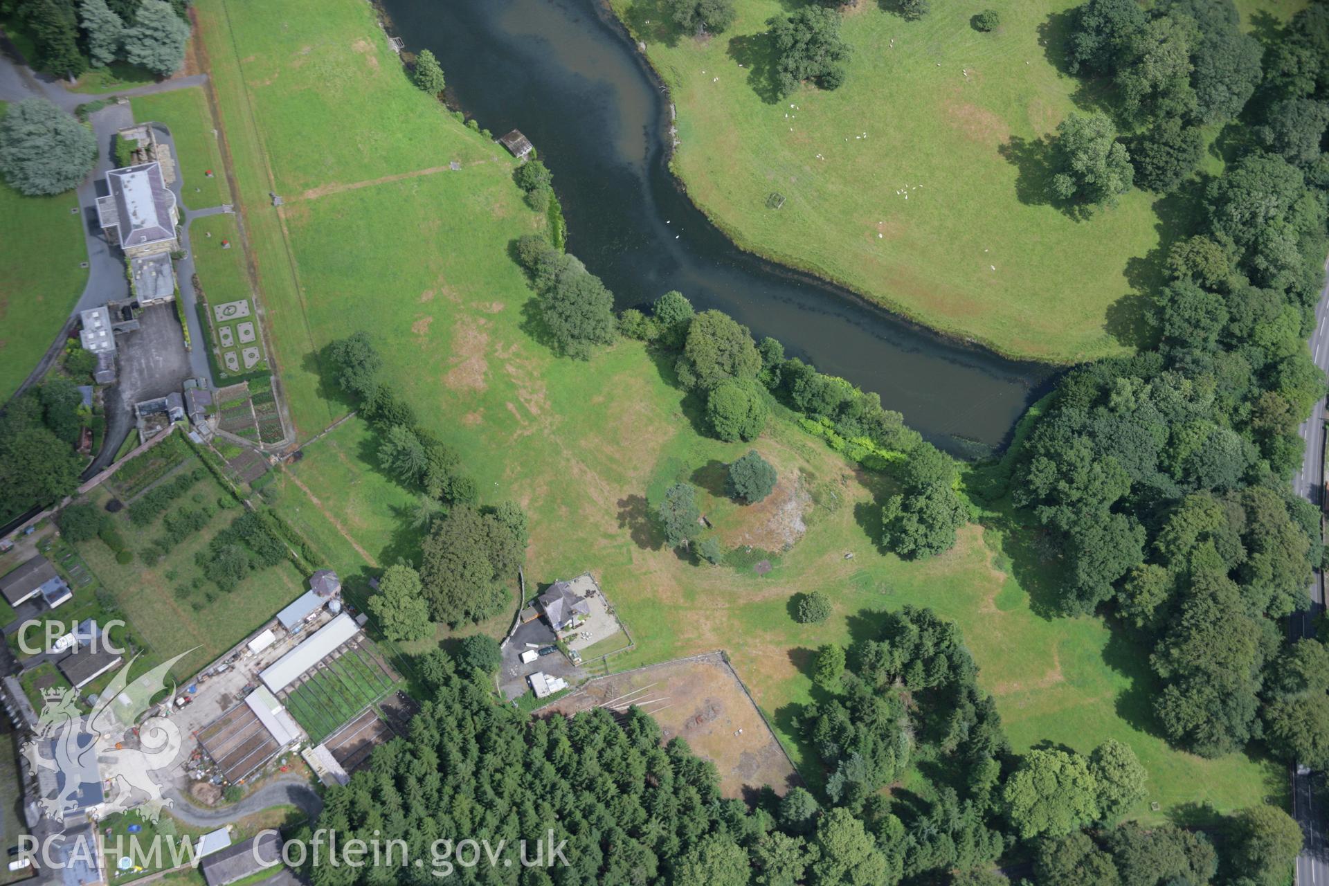 RCAHMW colour oblique aerial photograph of Rug Castle Mound and Prehistoric Funerary Monument with parchmarks showing. Taken on 31 July 2006 by Toby Driver.