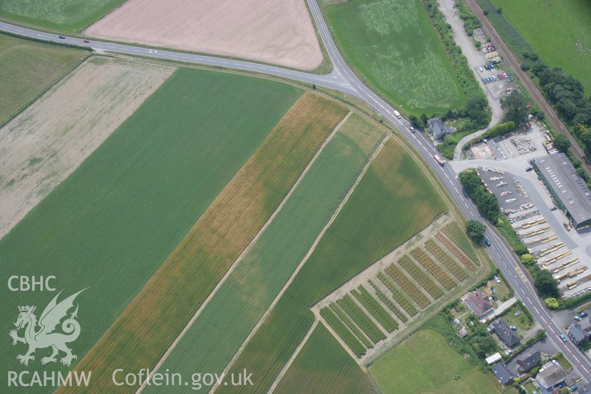 RCAHMW colour oblique aerial photograph of Bow Street Enclosure. Taken on 04 July 2006 by Toby Driver