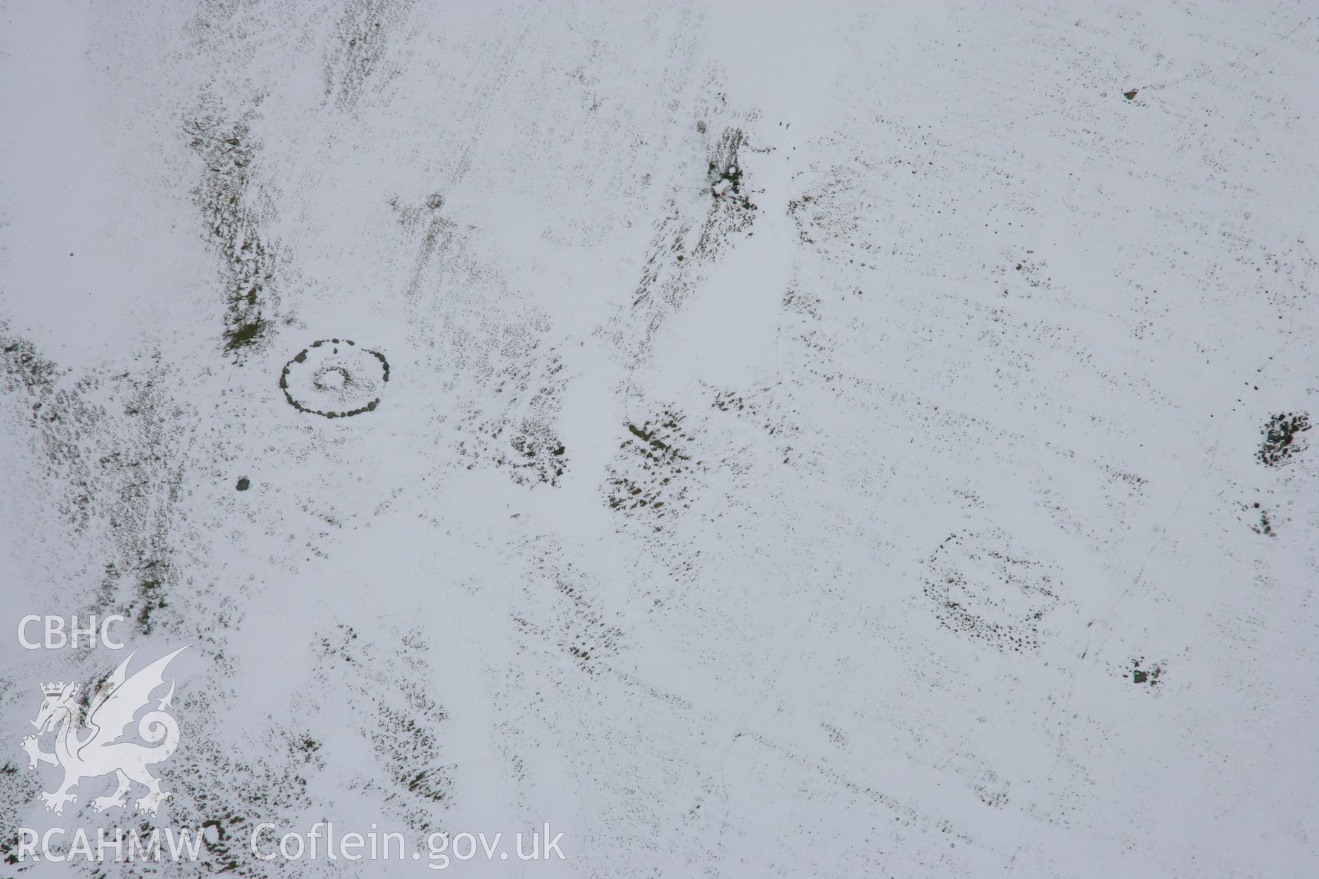 RCAHMW colour oblique aerial photograph of Moel Ty-Uchaf Kerb Circle, viewed under snow. Taken on 06 March 2006 by Toby Driver