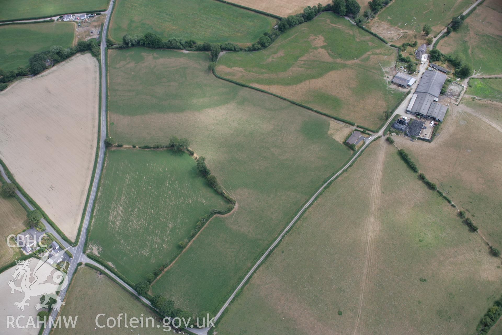 RCAHMW colour oblique aerial photograph of the rectangular enclosure and barrows at Pyllau-Isaf South showing cropmarks. Taken on 27 July 2006 by Toby Driver.