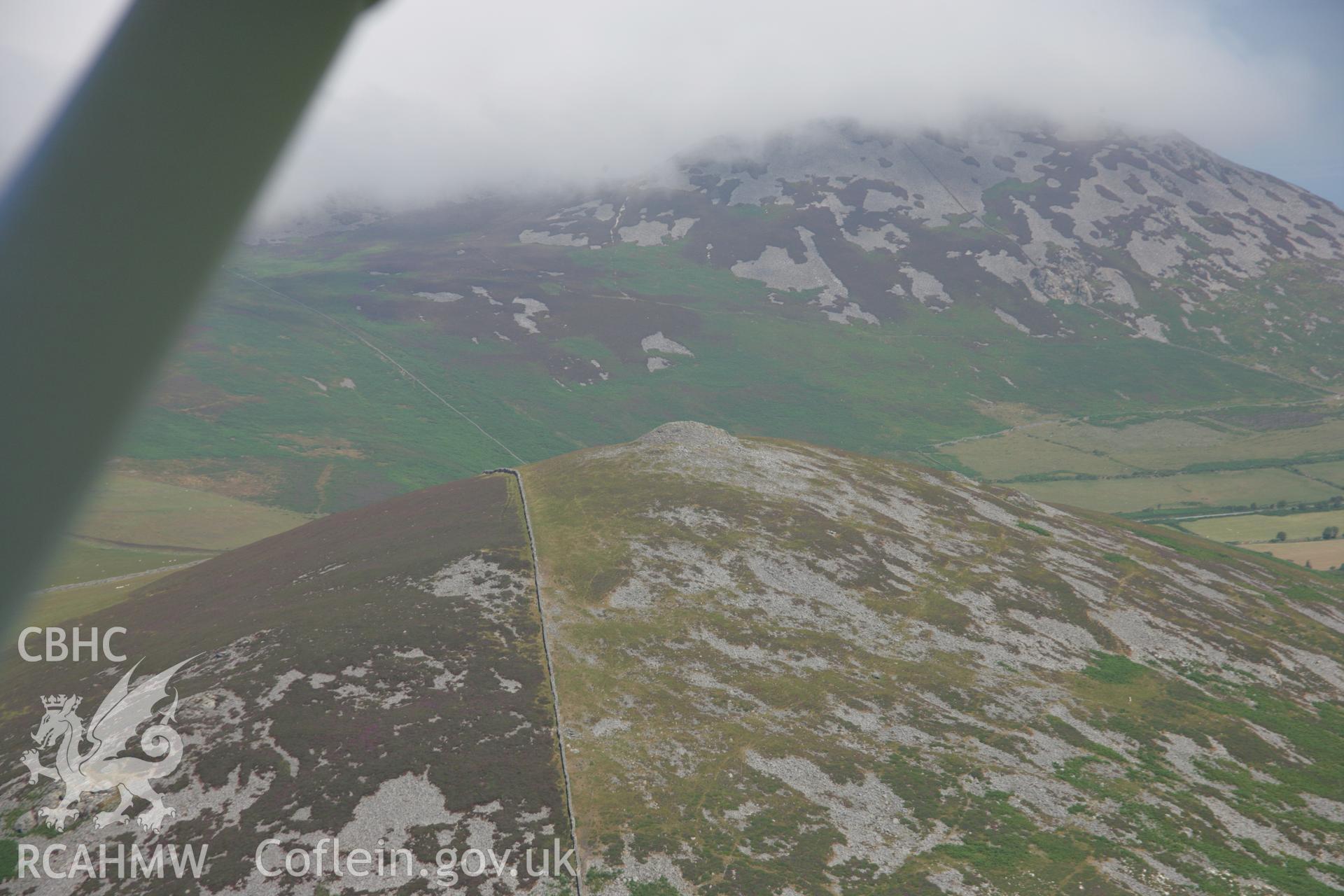 RCAHMW colour oblique aerial photograph of Carnguwch Cairn from the south. A passing shot through the aircraft window. Taken on 03 August 2006 by Toby Driver.