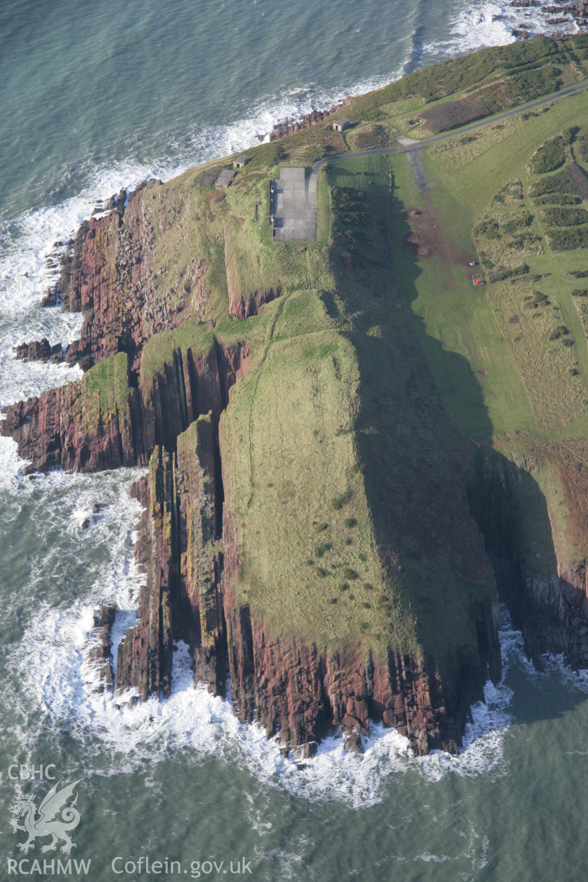 RCAHMW colour oblique aerial photograph of Old Castle Head Promontory Fort viewed looking west. Taken on 11 January 2006 by Toby Driver.