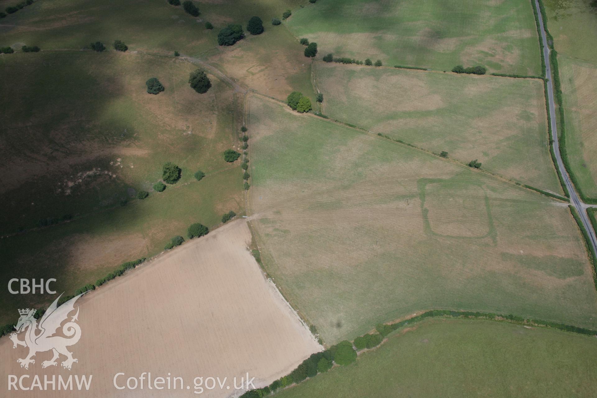 RCAHMW colour oblique aerial photograph of a bivallate enclosure west of Caerau, possibly representing a villa enclosure. Taken on 27 July 2006 by Toby Driver.