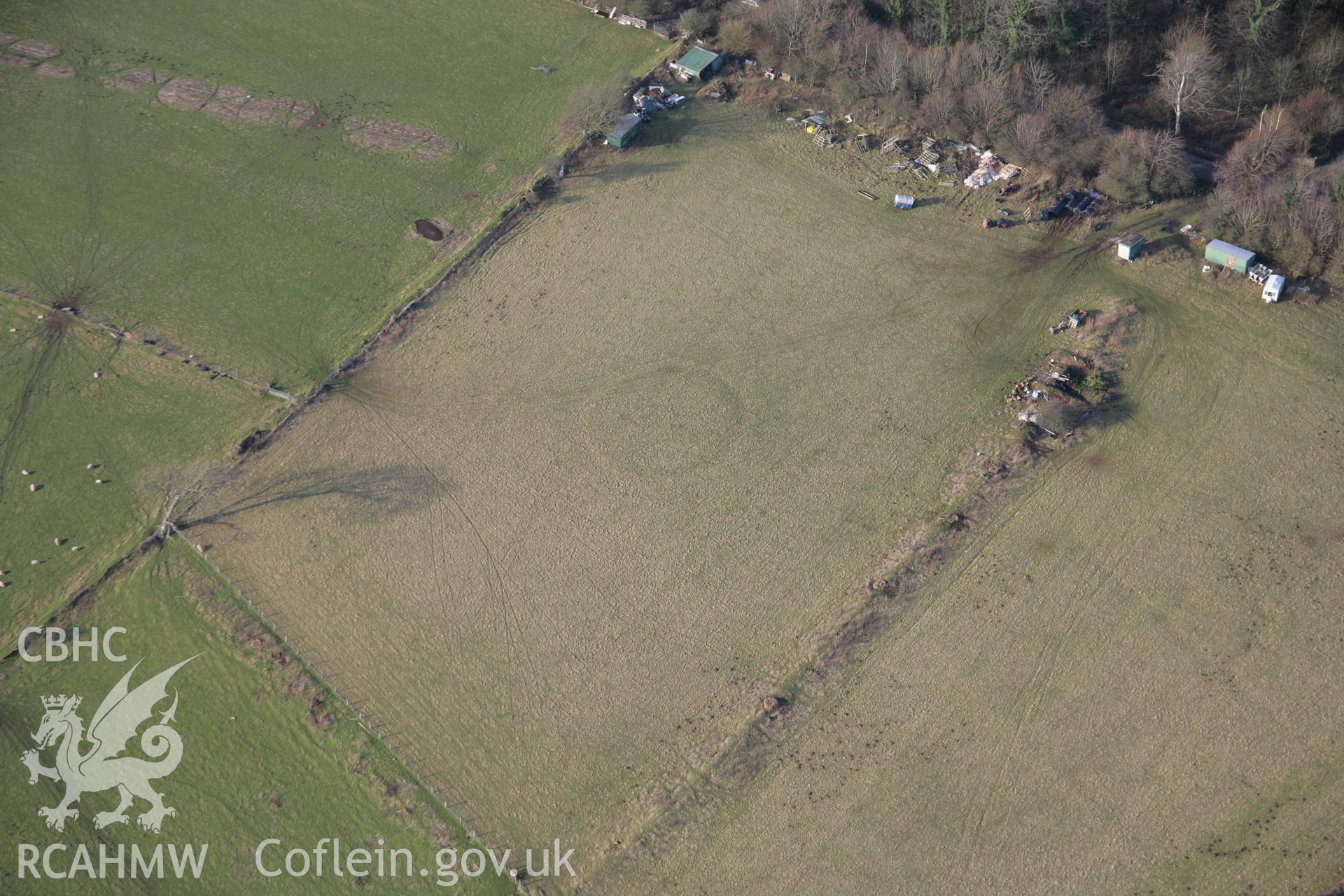 RCAHMW colour oblique aerial photograph of an earthwork enclosure south of Stout Hall viewed from the south-east. Taken on 26 January 2006 by Toby Driver.