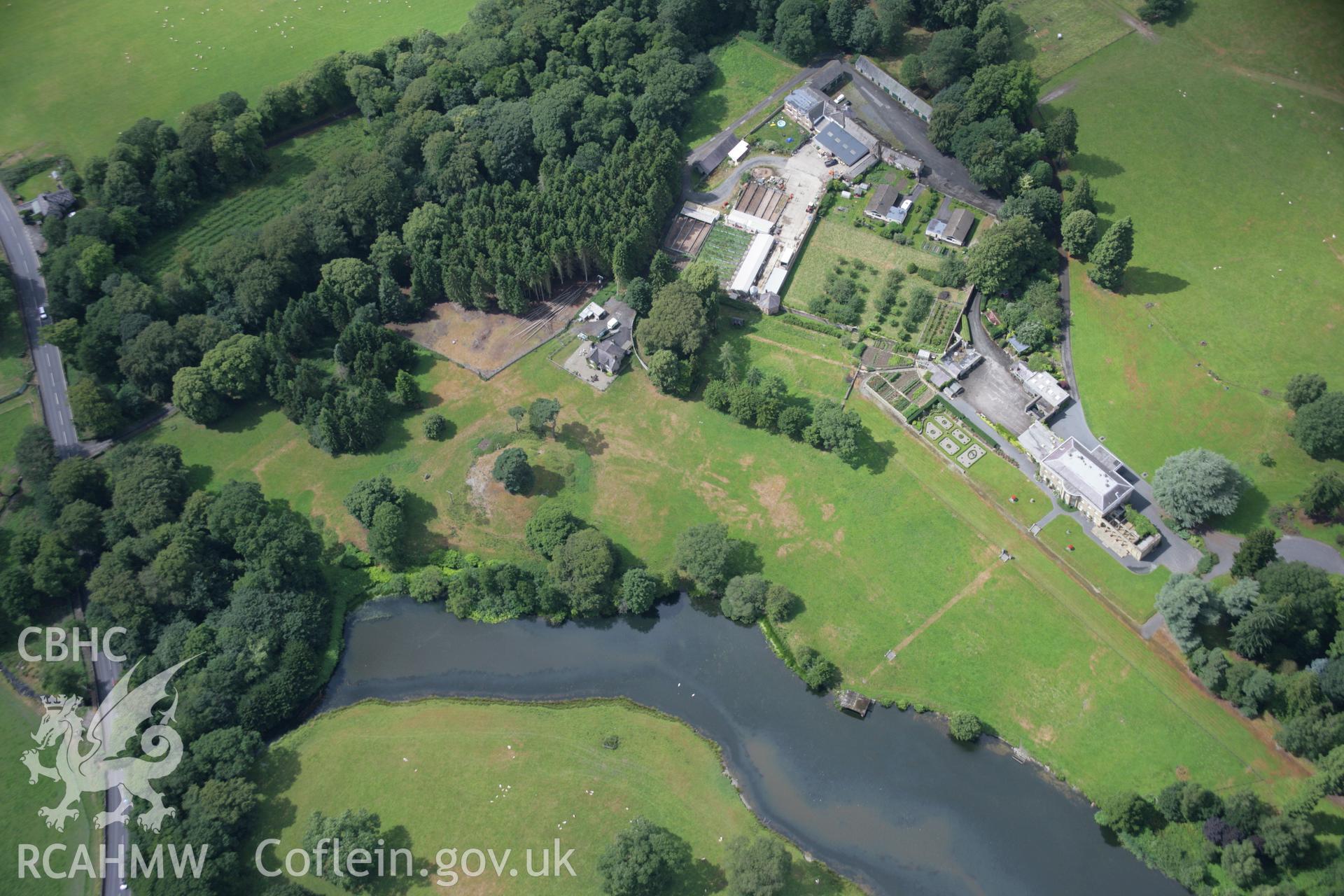 RCAHMW colour oblique aerial photograph of Rug Castle Mound and Prehistoric Funerary Monument with parchmarks showing. Taken on 31 July 2006 by Toby Driver.