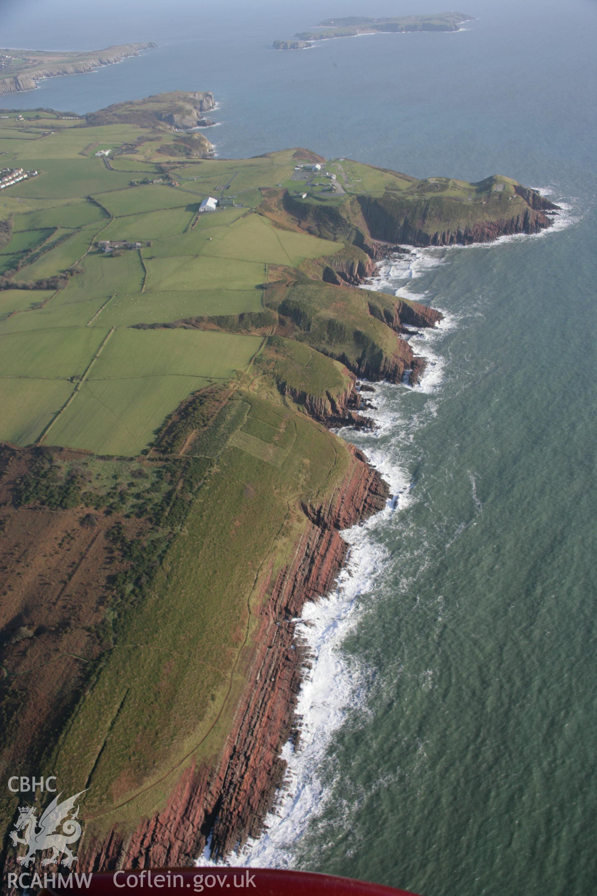 RCAHMW colour oblique aerial photograph of Old Castle Head Promontory Fort, in landscape view from the west. Taken on 11 January 2006 by Toby Driver.