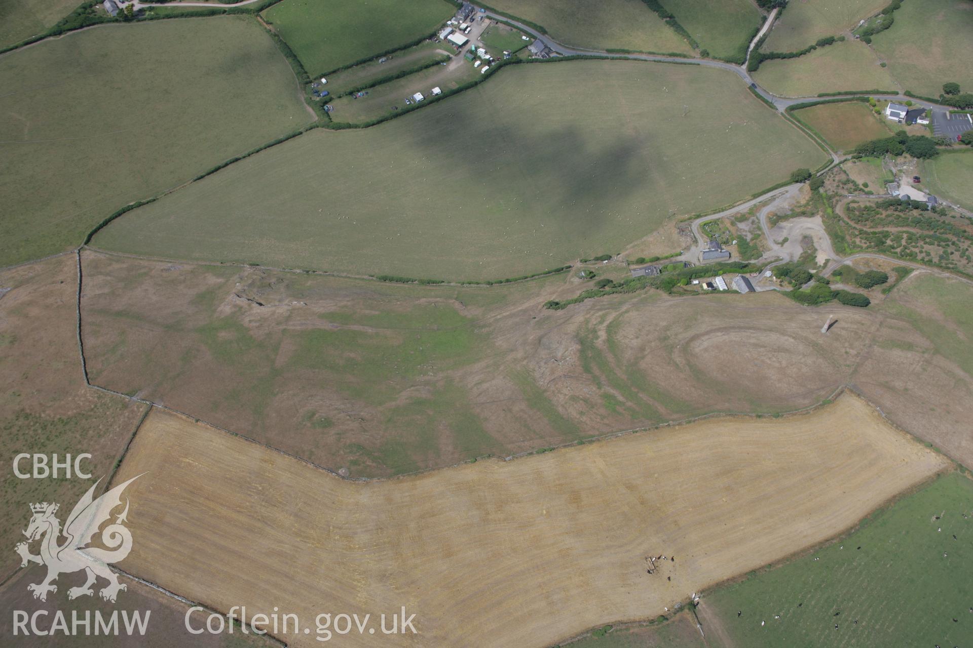 RCAHMW colour oblique aerial photograph of Castell Hillfort with parching on the hillside south of the fort. Taken on 03 August 2006 by Toby Driver.