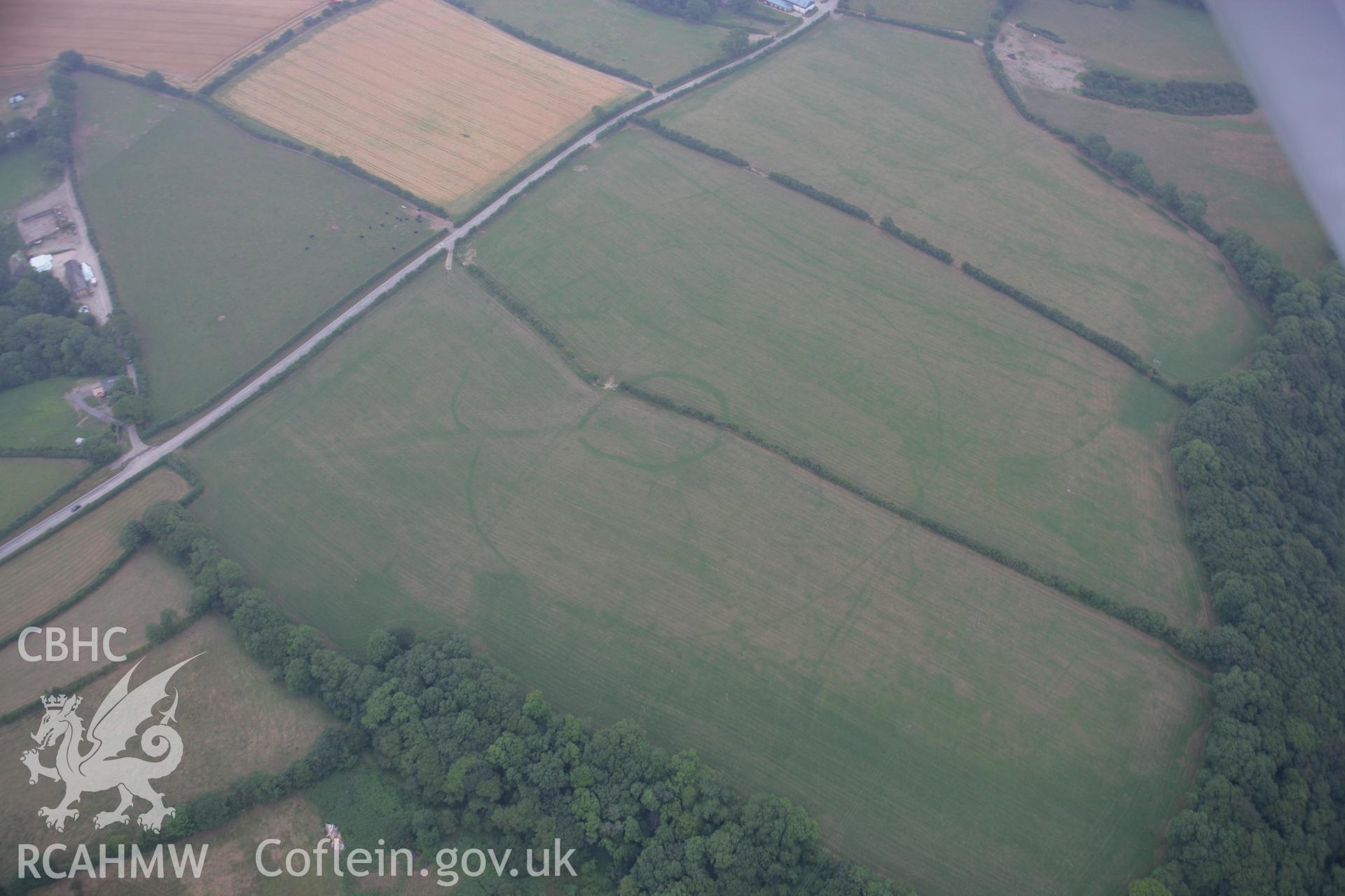 RCAHMW colour oblique aerial photograph of a concentric cropmark enclosure northwest of Brechfa. Taken on 21 July 2006 by Toby Driver.