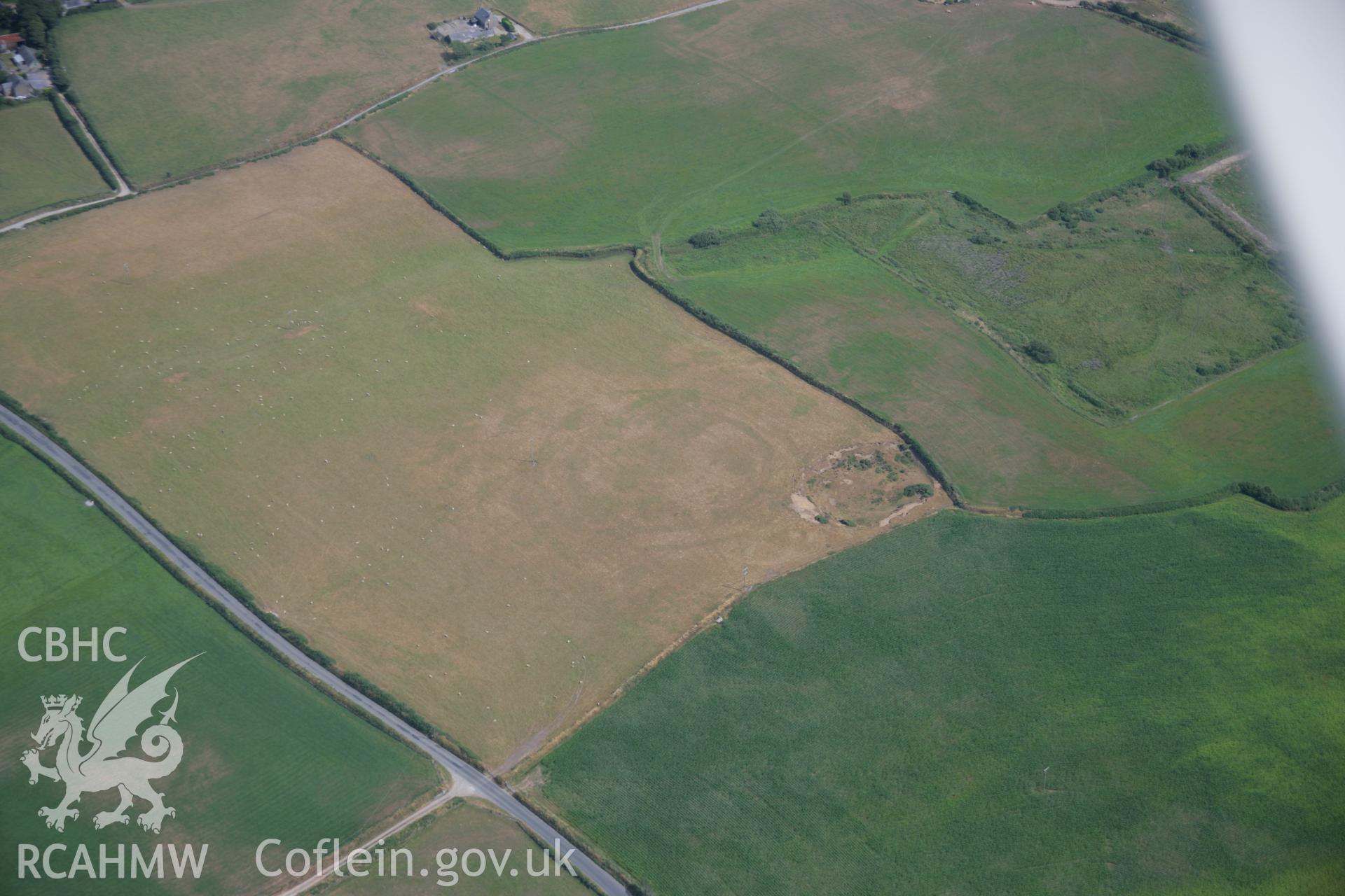 RCAHMW colour oblique aerial photograph of a cropmark enclosure south of Bryniau. Taken on 25 July 2006 by Toby Driver.