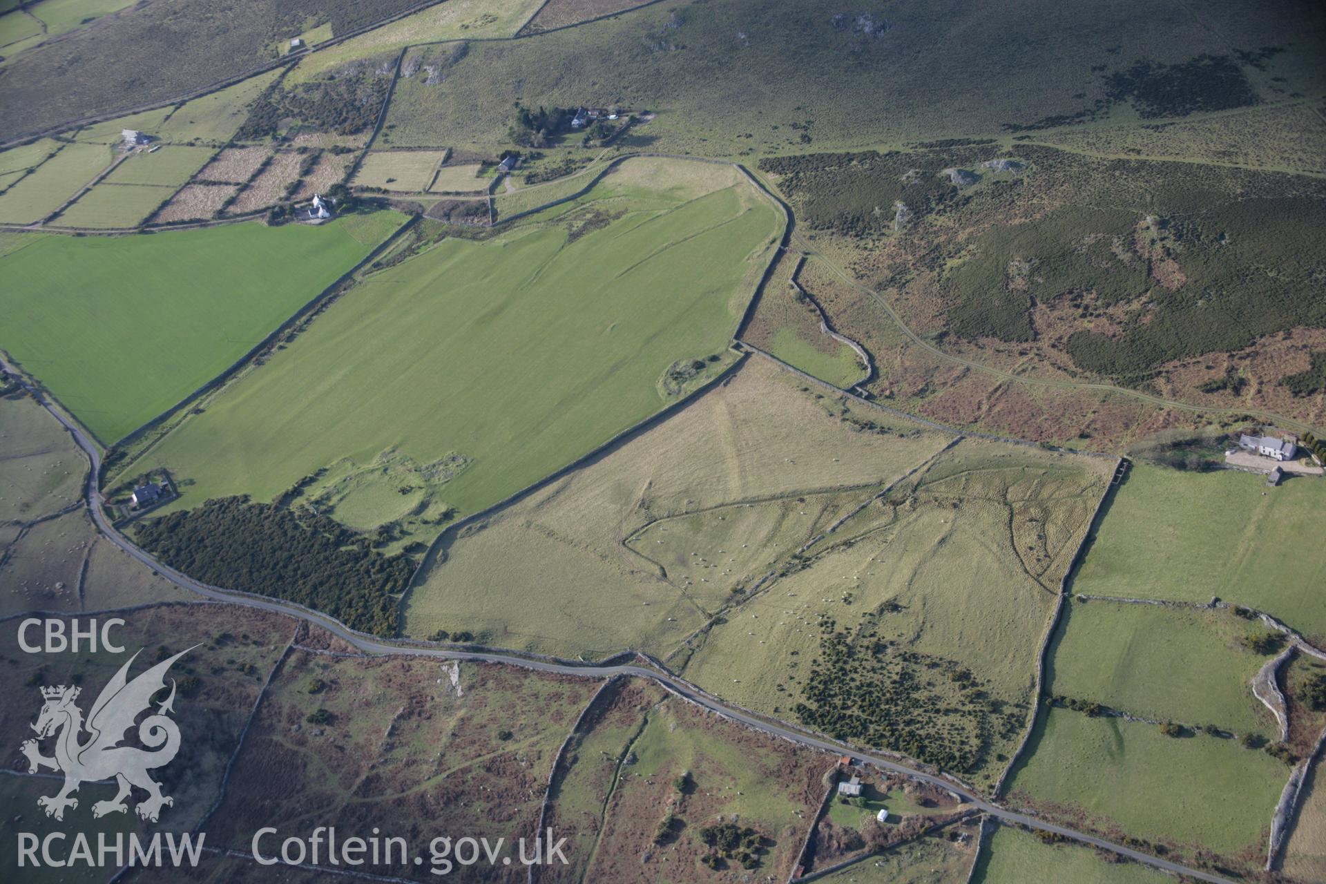 RCAHMW colour oblique aerial photograph of Rhiw Defended Enclosure. A landscape view from the east. Taken on 09 February 2006 by Toby Driver.