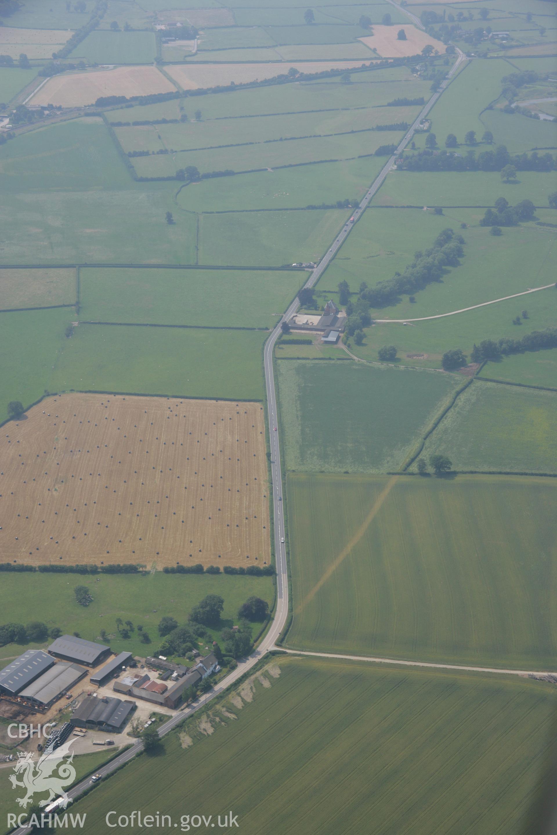 RCAHMW colour oblique aerial photograph of a section of Roman Road at Maes-Mawr Hall. Taken on 04 July 2006 by Toby Driver.