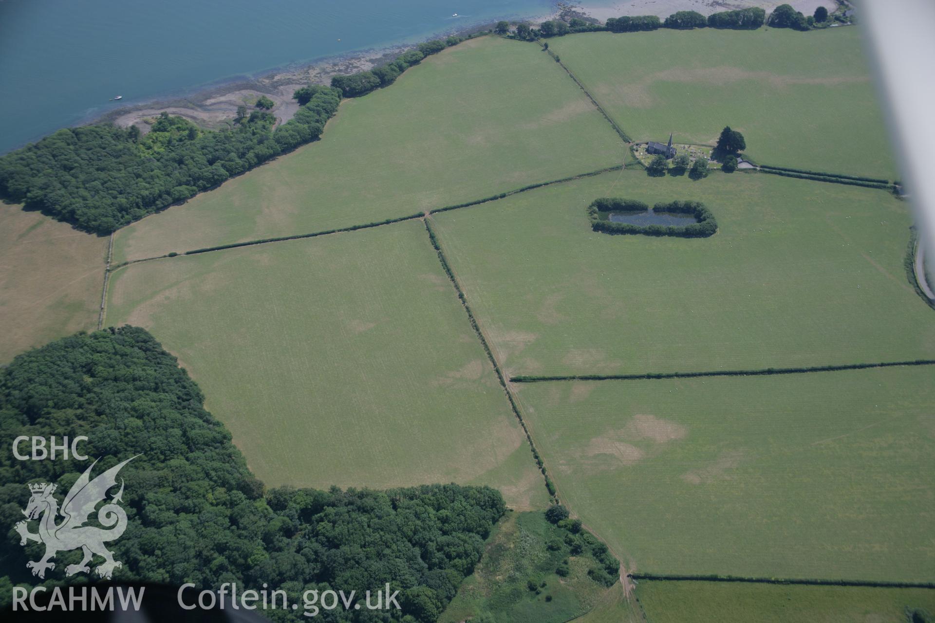 RCAHMW colour oblique aerial photograph of St Edwen's Church, Llanedwen showing nearby parchmarks. Taken on 18 July 2006 by Toby Driver.