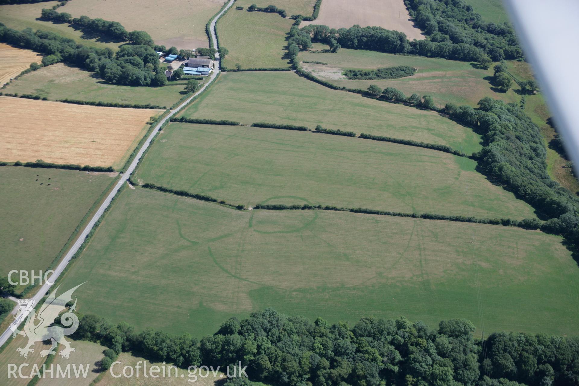 RCAHMW colour oblique aerial photograph of a concentric cropmark enclosure northwest of Brechfa. Taken on 24 July 2006 by Toby Driver.