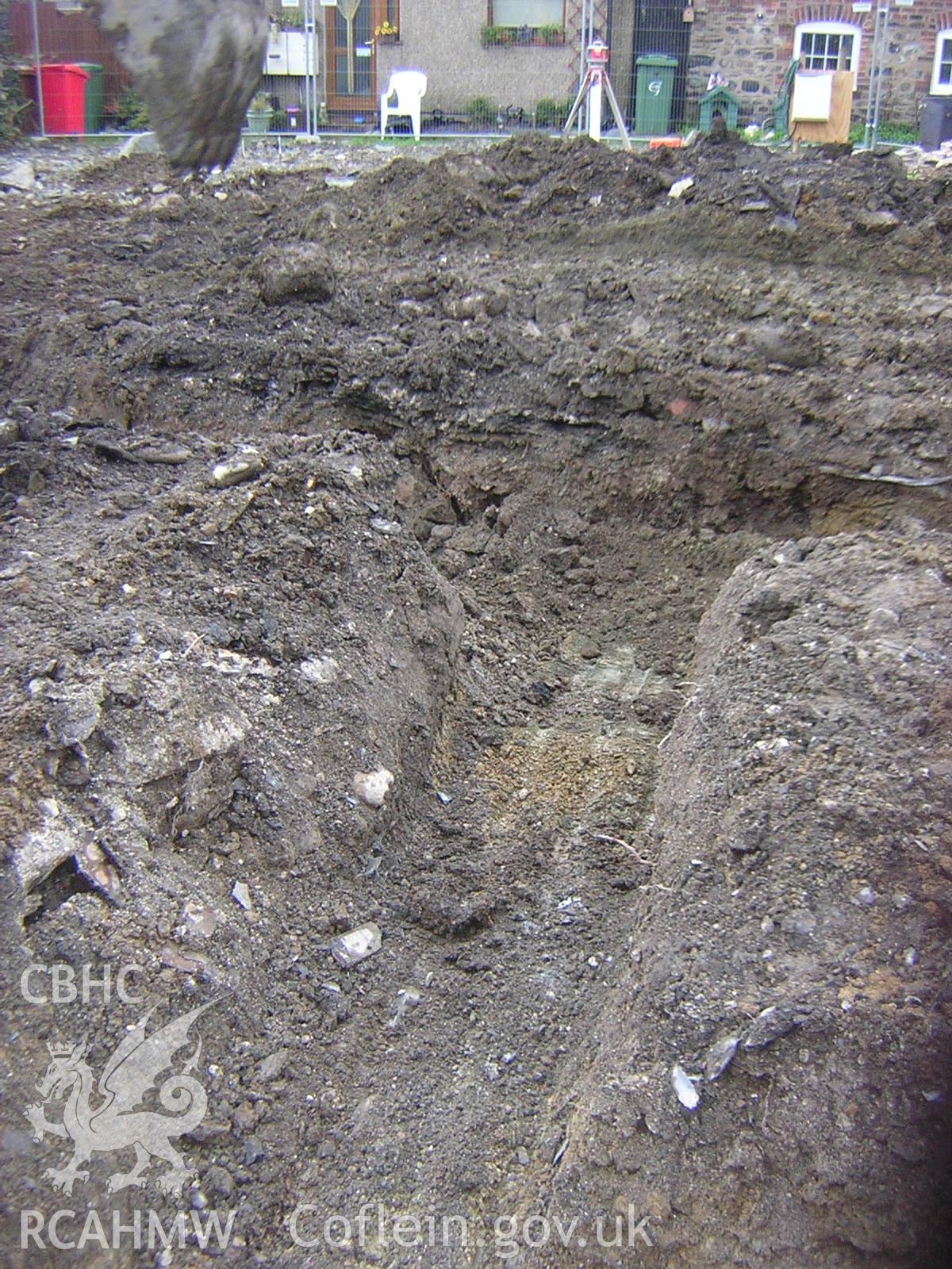 Plate 6: photograph showing view of trench in area of backfilled cellar feature; part of Desk Based Research & Watching Brief for Red Lion Street, Tywyn Gwynedd', report no. 1128. Produced by Archaeology Wales in 2012.