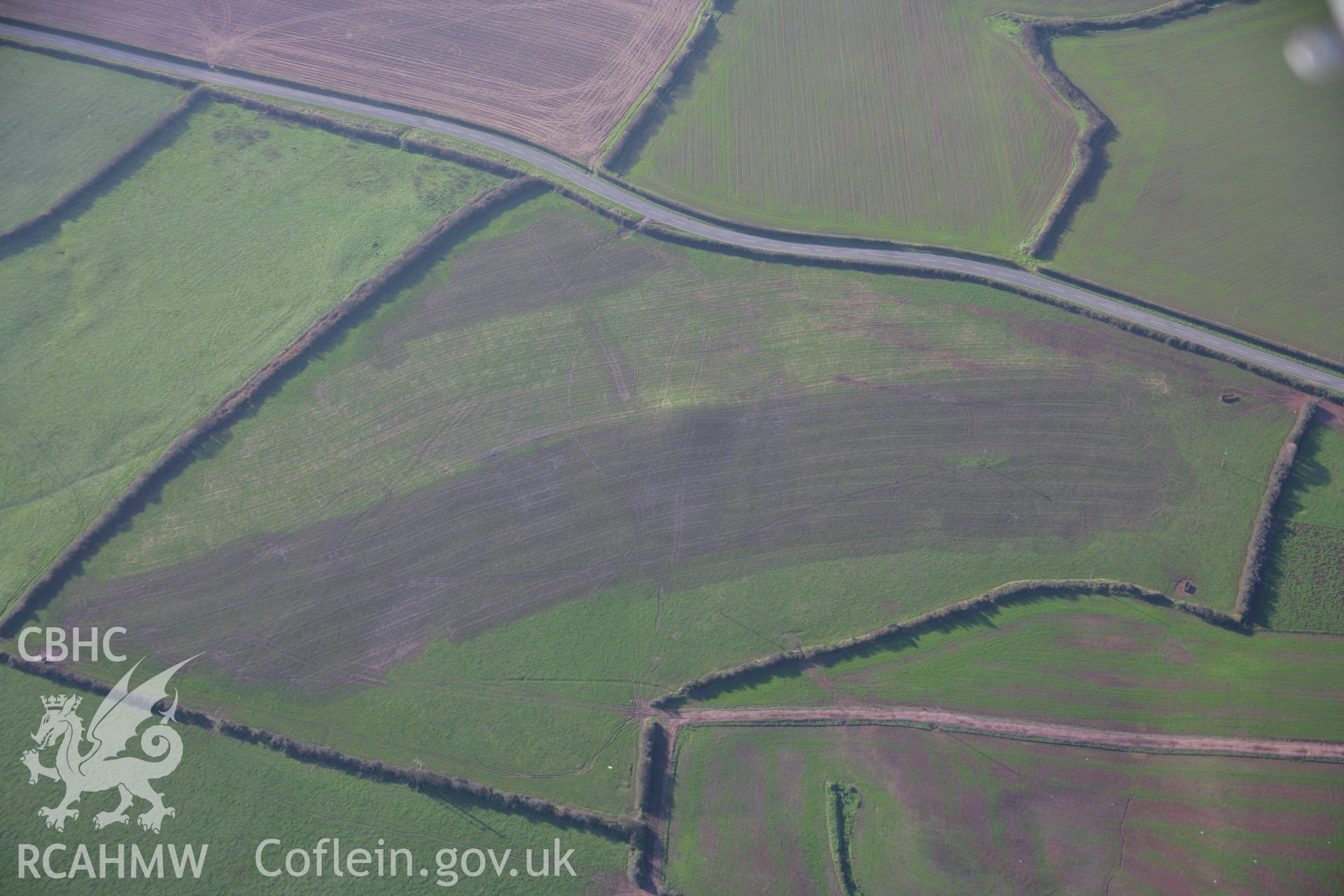 RCAHMW colour oblique aerial photograph of Wallaston Round Round Barrows I, II, III and IV viewed from the north-east, with muck-spreading. Taken on 19 November 2005 by Toby Driver