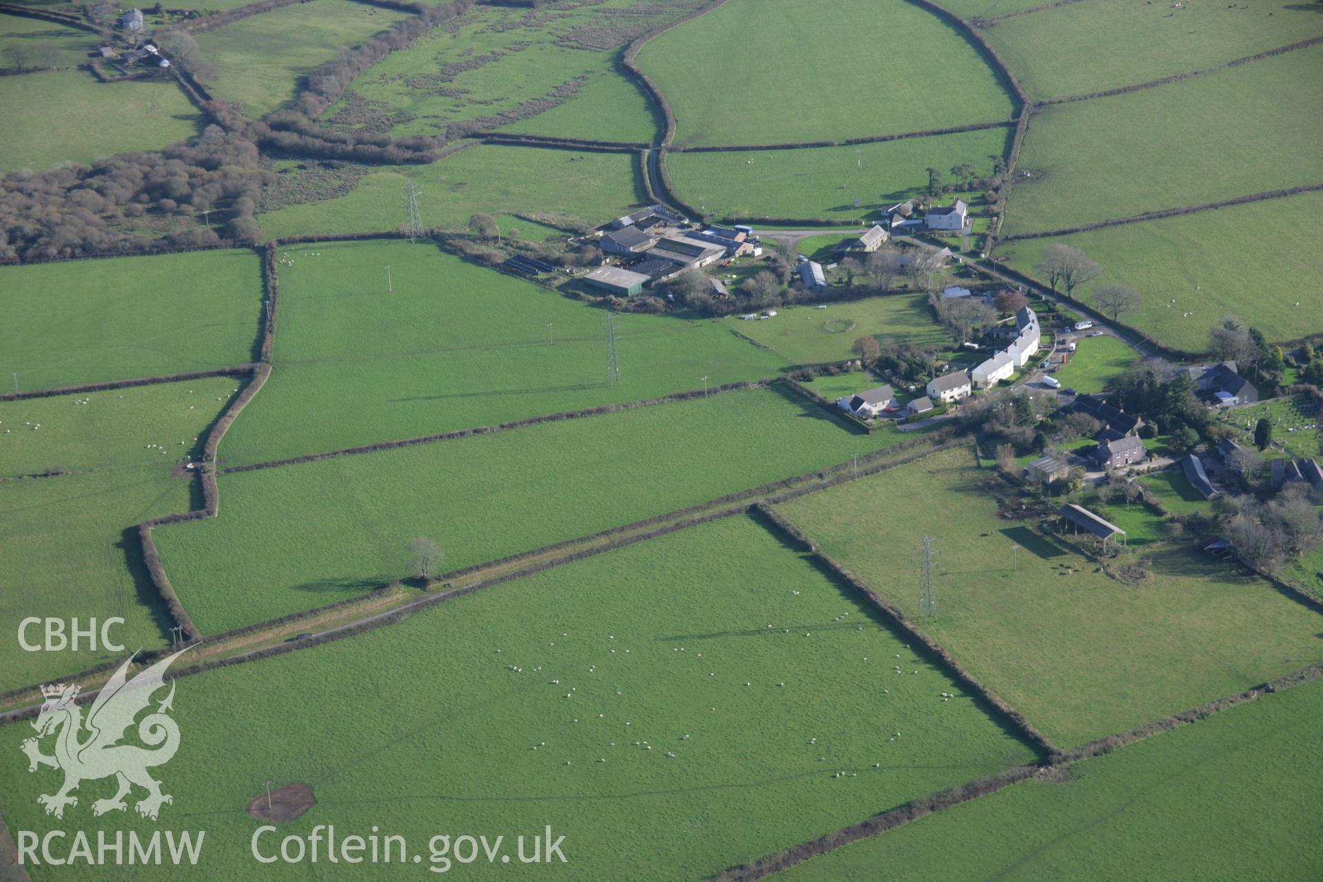 RCAHMW colour oblique aerial photograph of Uzmaston Barrow from the north-west, also showing the nearby village. Taken on 19 November 2005 by Toby Driver