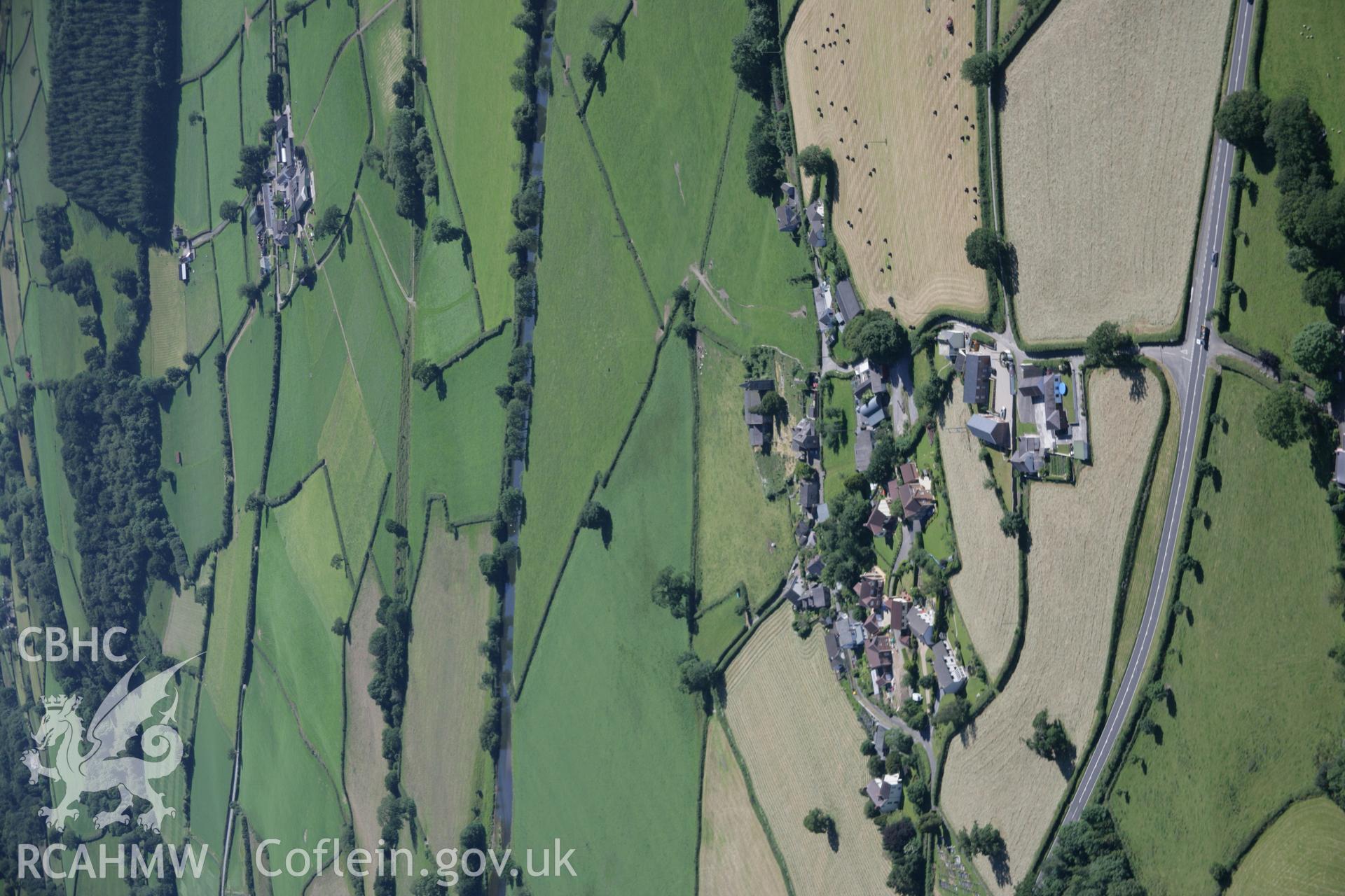 RCAHMW colour oblique aerial photograph of St Egwad's Church, Llanegwad village, viewed from the north with Afon Twyi beyond. Taken on 22 June 2005 by Toby Driver