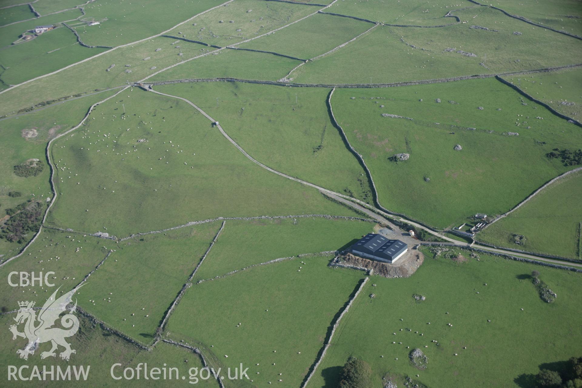 RCAHMW colour oblique aerial photograph of Carn-Gadell Uchaf Corn Drying Kiln, Llwyngwril, from the north-west showing new agricultural sheds. Taken on 17 October 2005 by Toby Driver