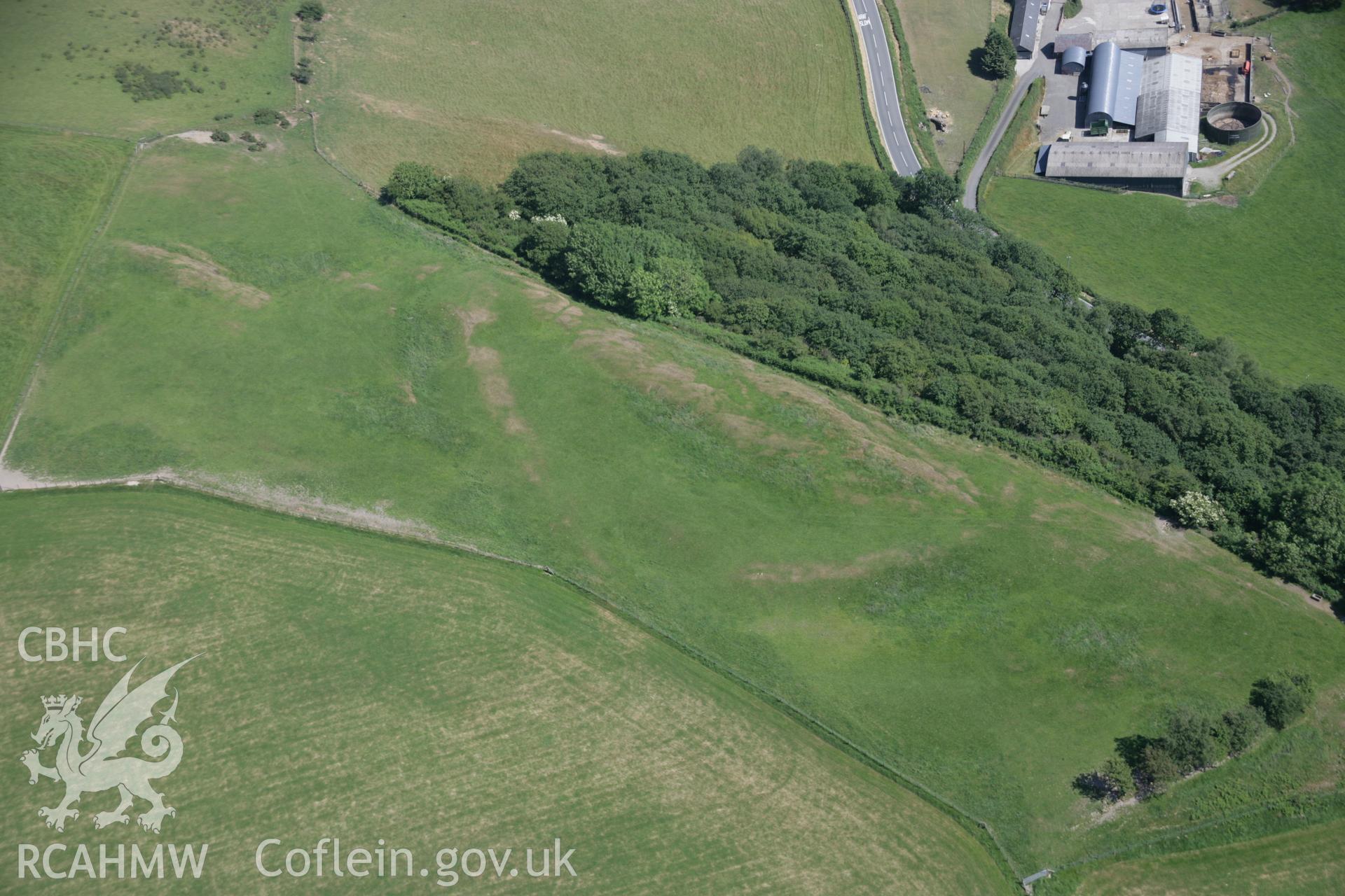 RCAHMW colour oblique aerial photograph of Coed-Parc Gaer, Llangybi, with parching on ramparts, viewed from the north-west. Taken on 23 June 2005 by Toby Driver