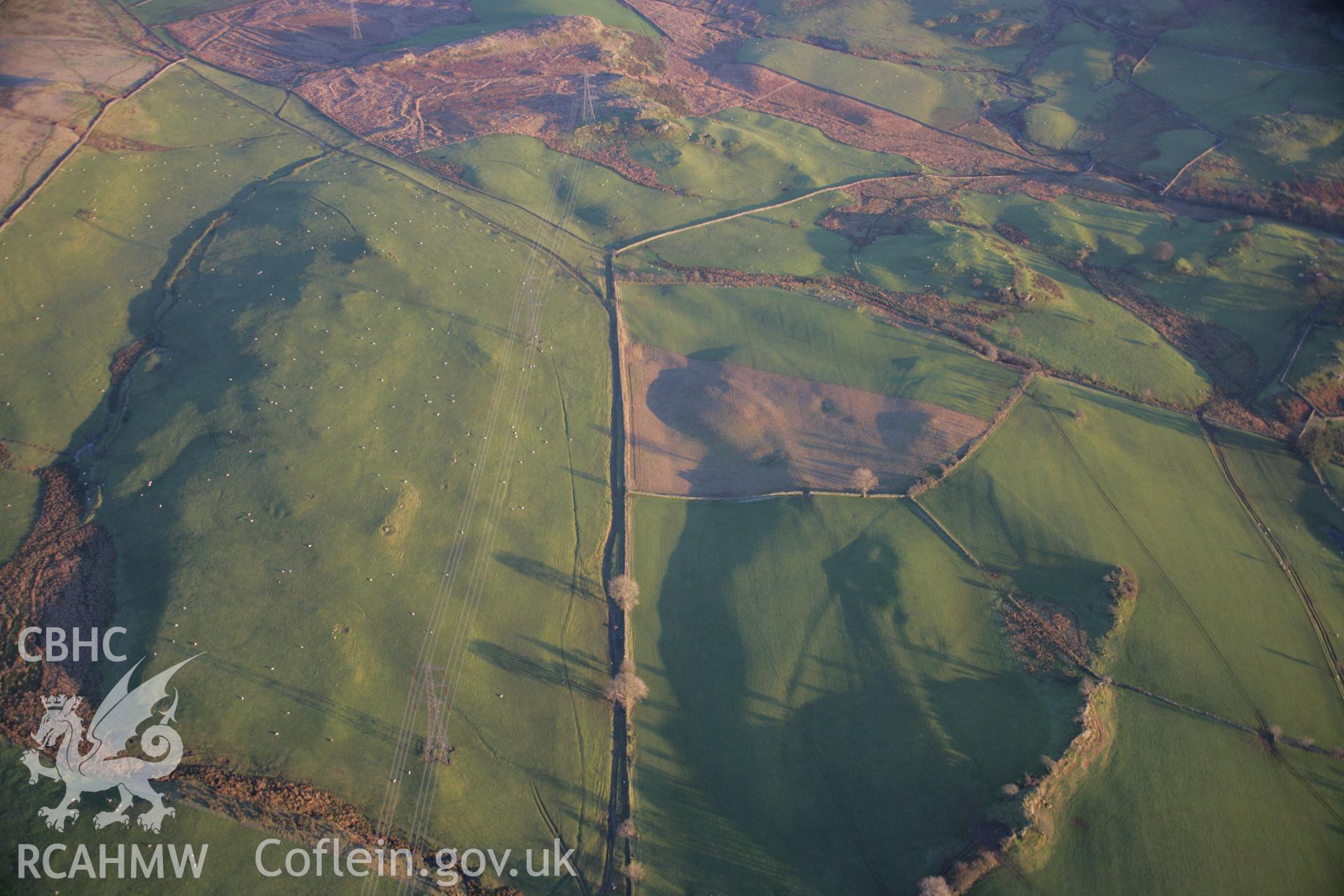 RCAHMW colour oblique aerial photograph of the Roman Road west of Dolbelydr from the west. The road shows as a low earthwork. Taken on 21 November 2005 by Toby Driver