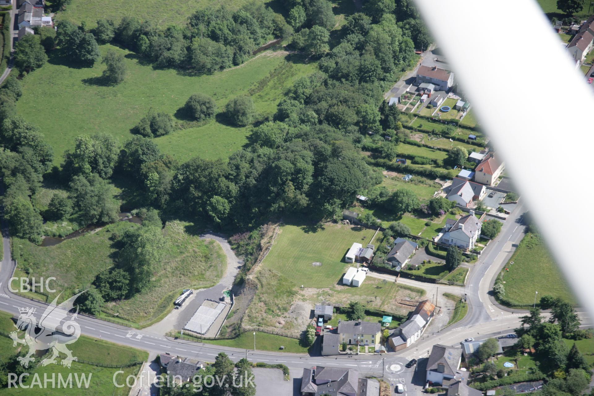 RCAHMW colour oblique aerial photograph of Llanwnnen Castle showing wooded motte and bailey. Taken on 23 June 2005 by Toby Driver