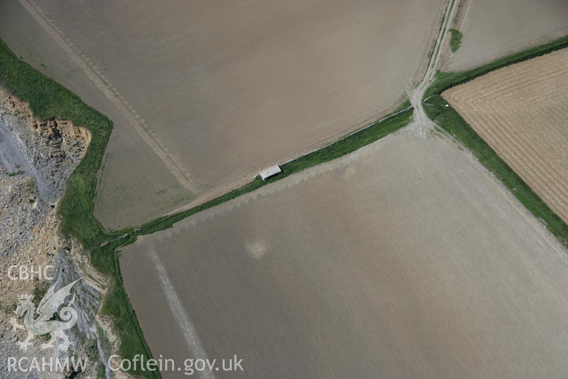 RCAHMW colour oblique aerial photograph of Nash Point showing soilmark of pair of round barrows. Taken on 22 June 2005 by Toby Driver