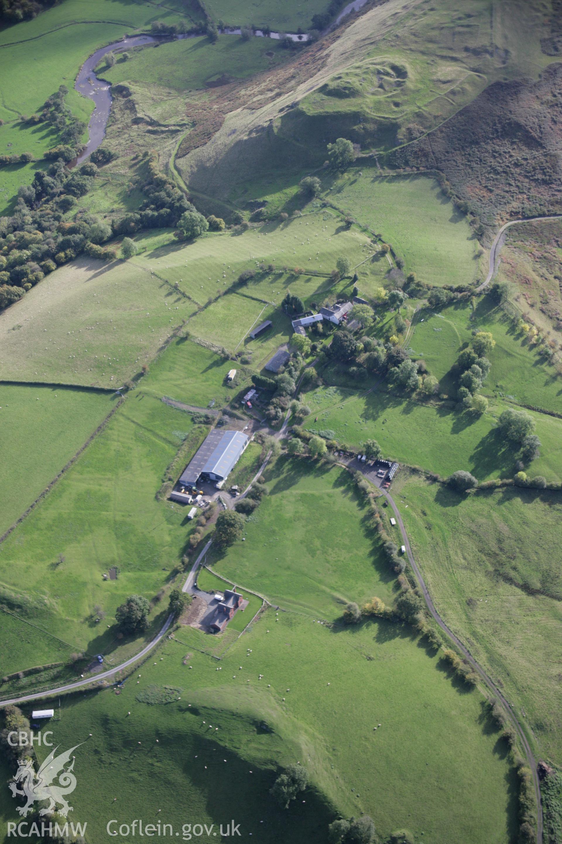 RCAHMW colour oblique aerial photograph of Neuadd longhouse and earthworks on crest of ridge, viewed from the south looking towards Cefnllys Castle Taken on 13 October 2005 by Toby Driver