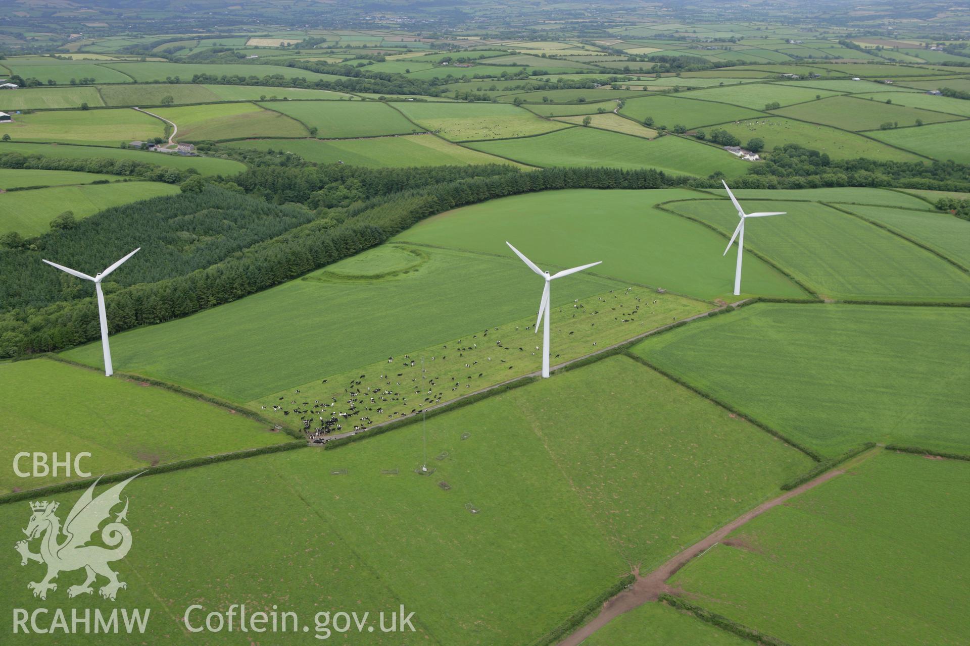 RCAHMW colour oblique photograph of Parc Cynog Farm Hillfort, with windfarm. Taken by Toby Driver on 20/06/2008.