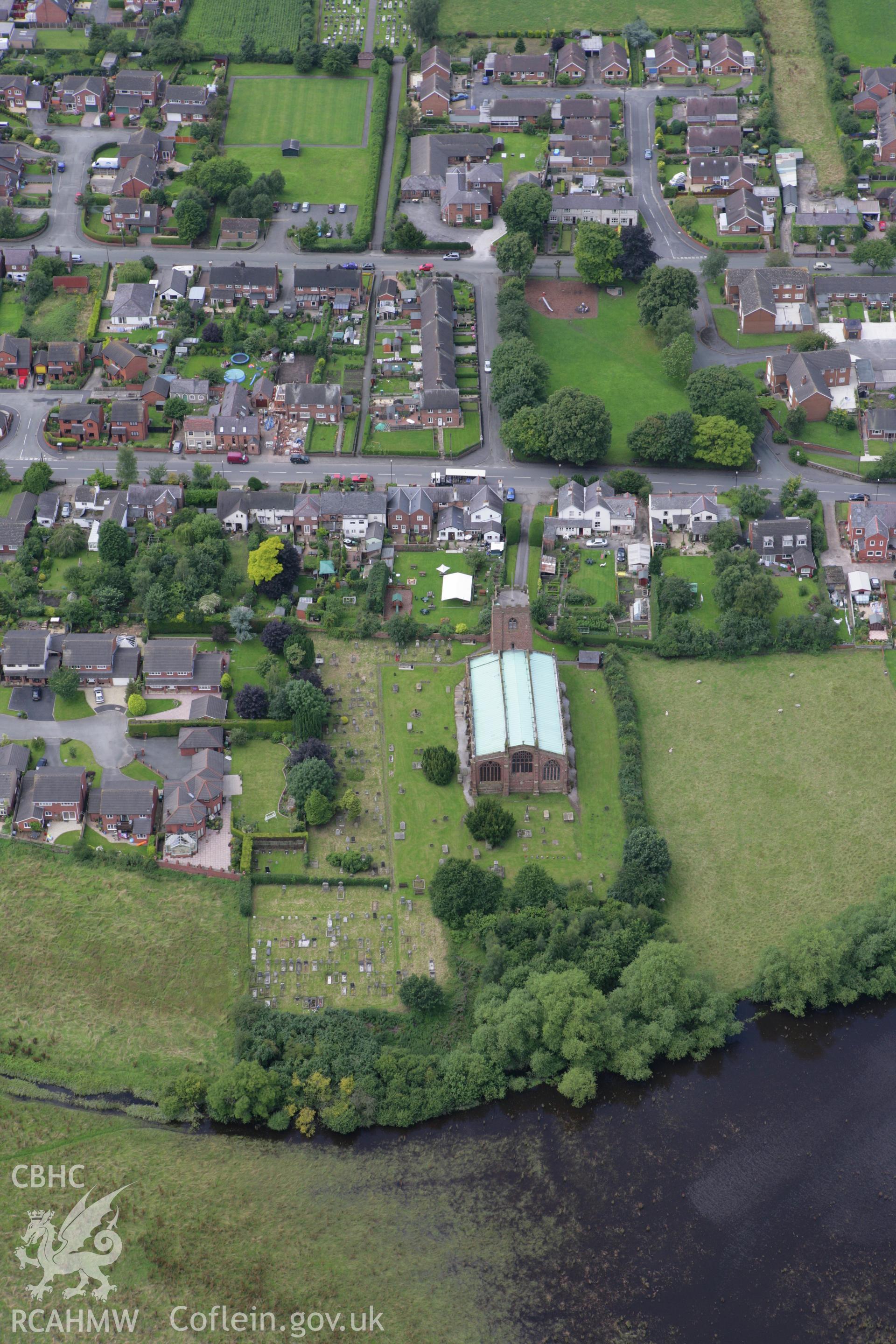 RCAHMW colour oblique aerial photograph of St Chad's Church, Holt, showing flooding from River Dee. Taken on 24 July 2007 by Toby Driver