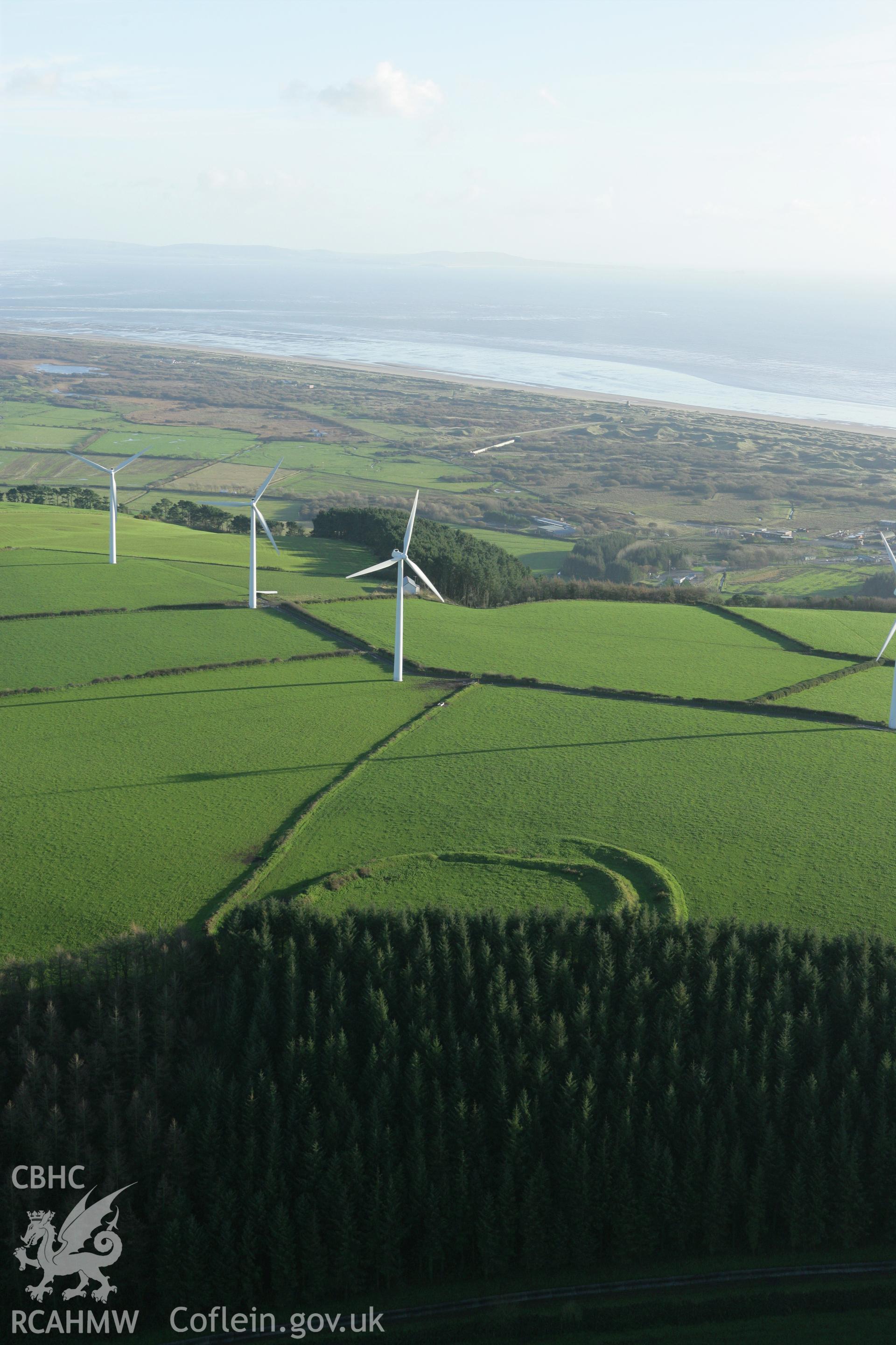 RCAHMW colour oblique photograph of Parc Cynog Farm hillfort;Wind Farm, Llanmiloe. Taken by Toby Driver on 29/11/2007.