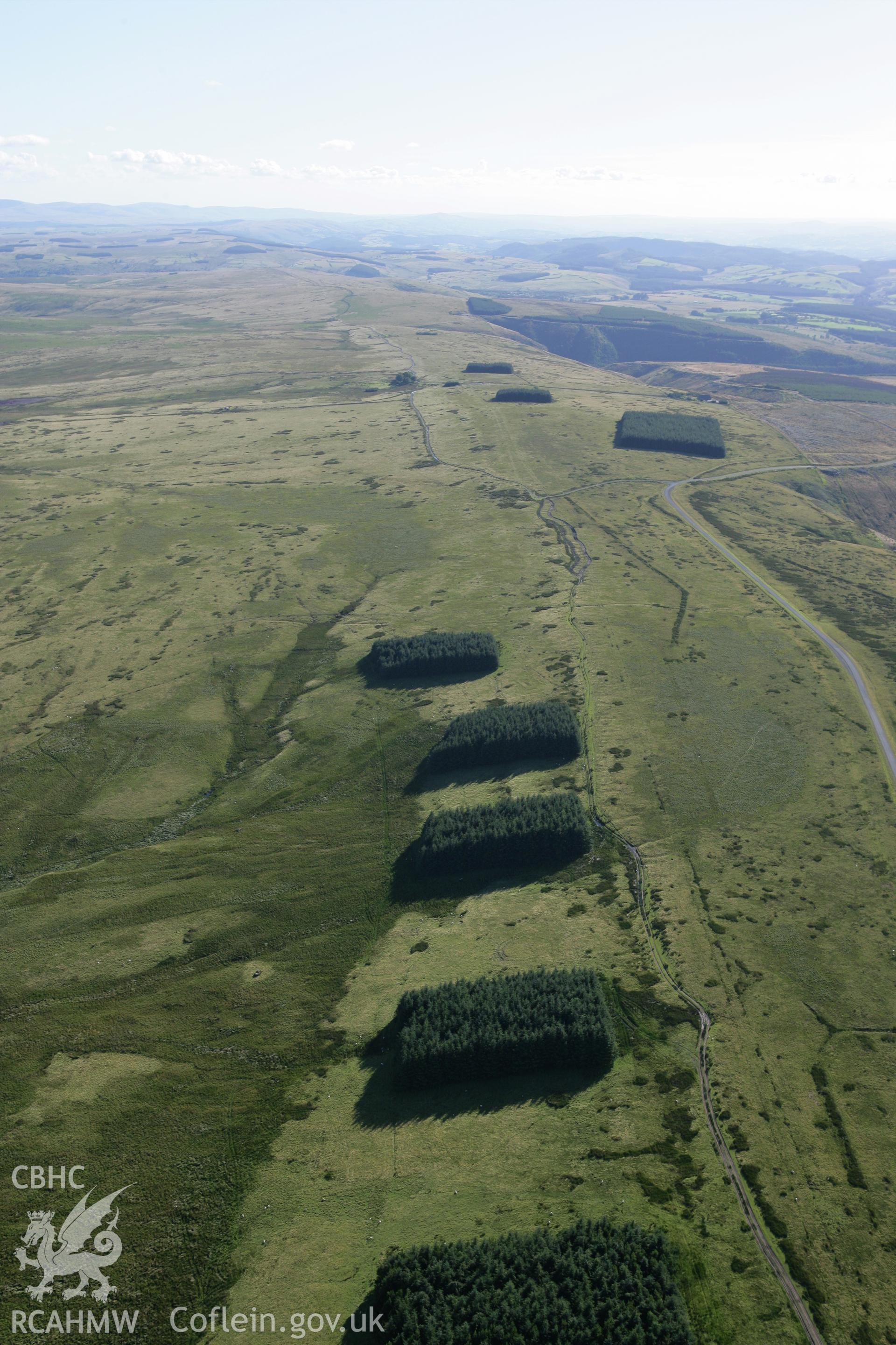 RCAHMW colour oblique aerial photograph of Tri Chrugiau Cairn I, II, III and surrounding landscape, viewed from the north-east. Taken on 08 August 2007 by Toby Driver