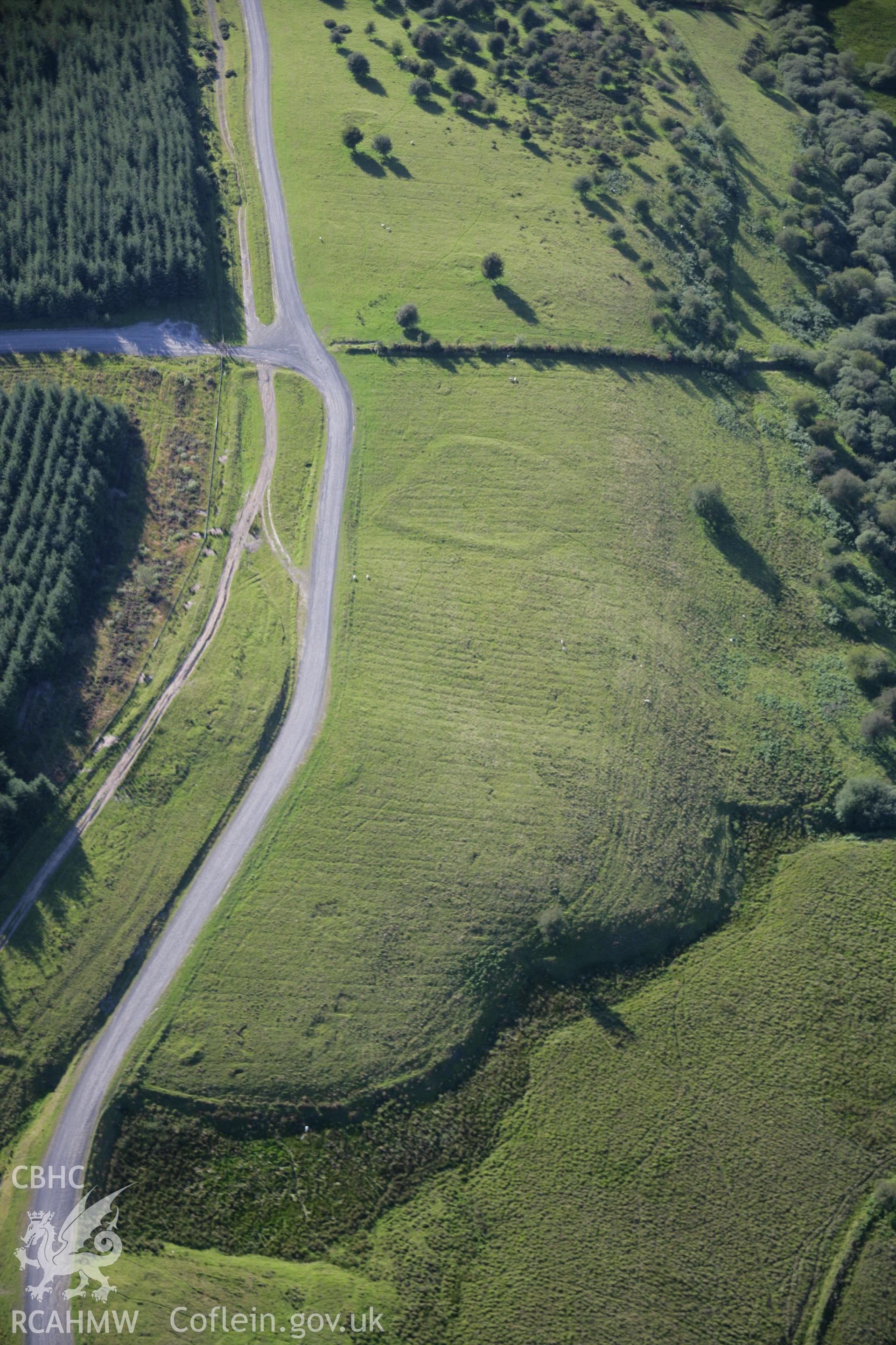 RCAHMW colour oblique aerial photograph of Dixies Corner Enclosure, Llandeilor Fan. Taken on 08 August 2007 by Toby Driver