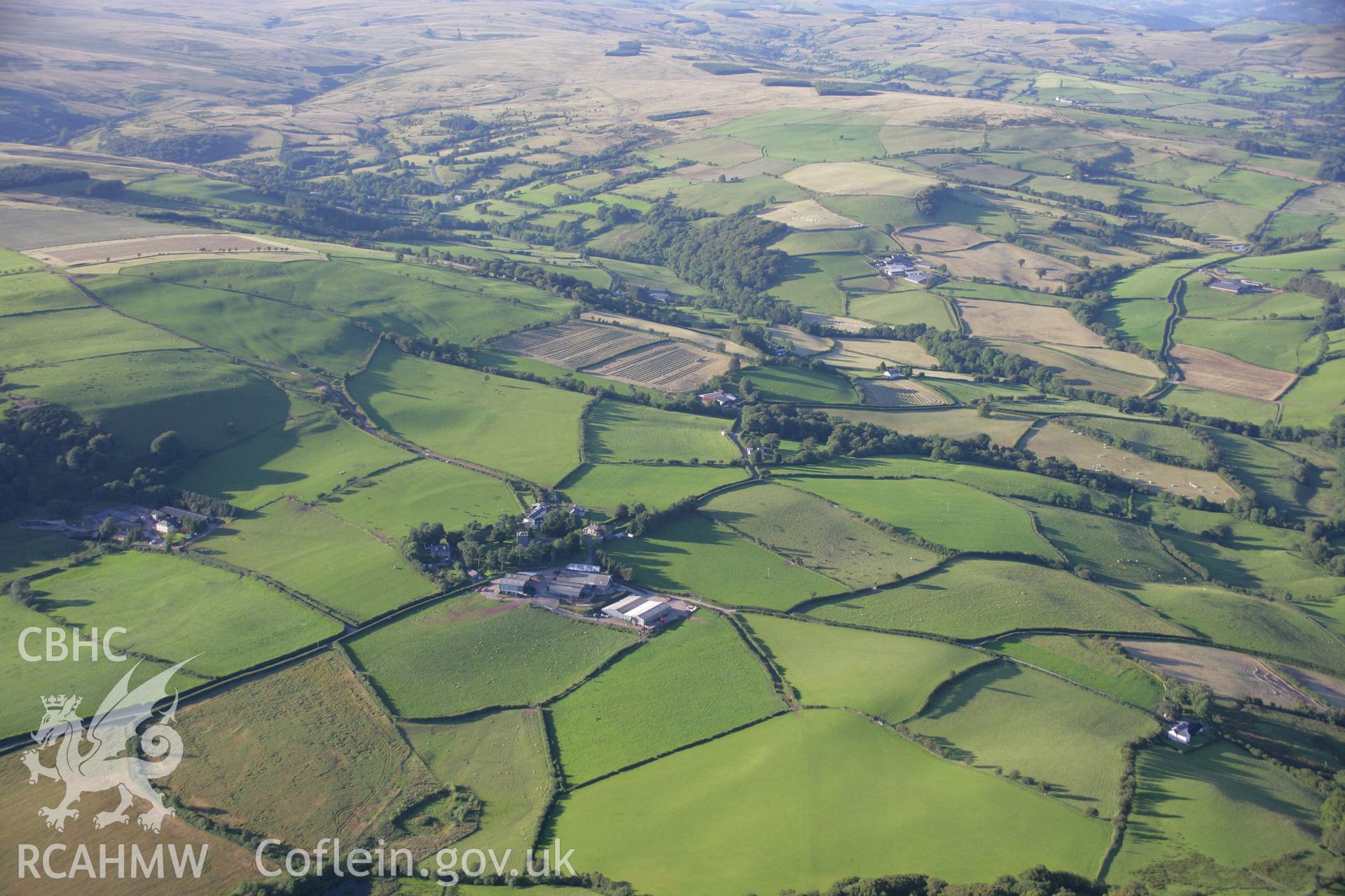 RCAHMW colour oblique aerial photograph of Merthyr Cynog in wide landscape view showing earthworks. Taken on 08 August 2007 by Toby Driver