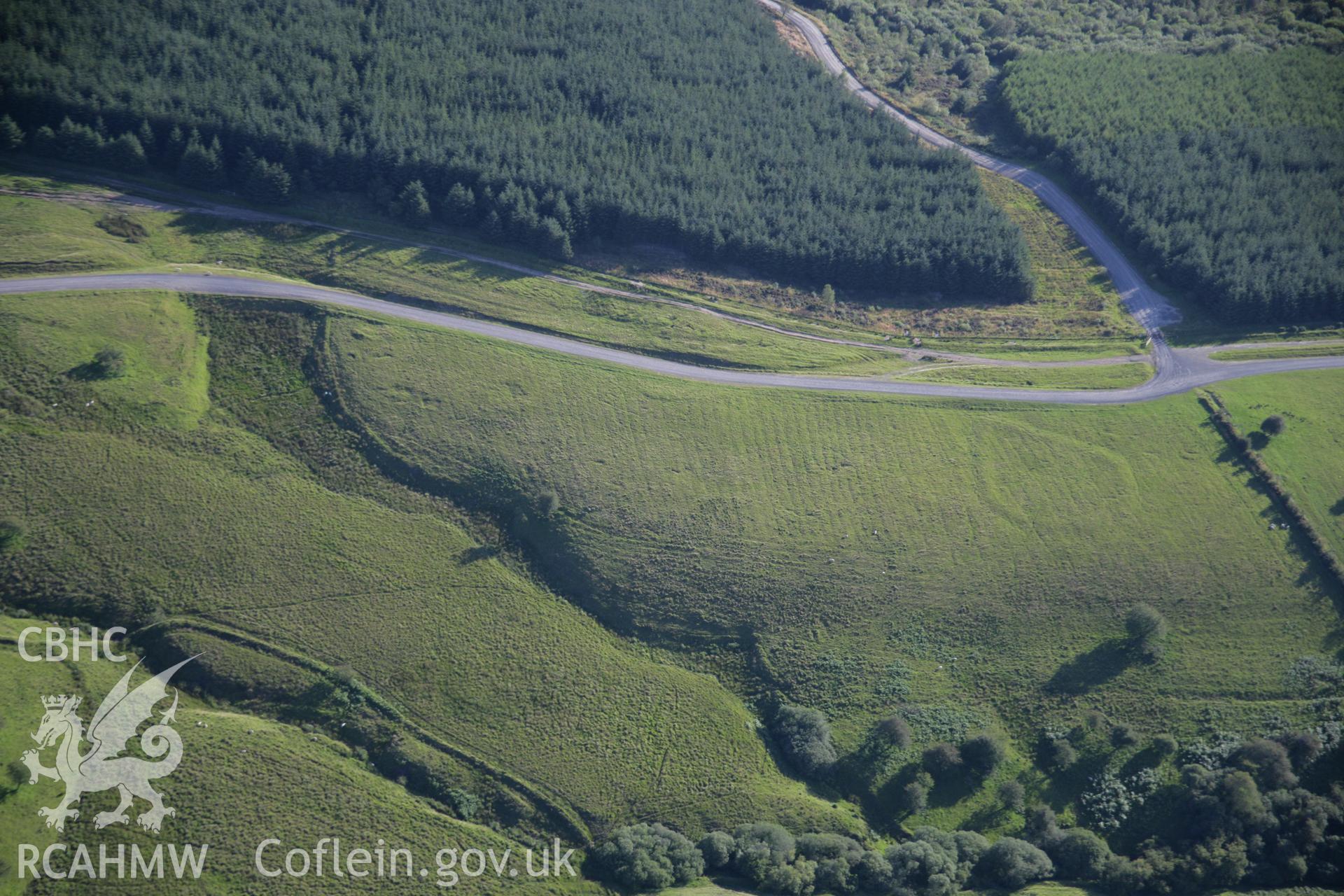 RCAHMW colour oblique aerial photograph of Hirllwyn Enclosure, Llandeilor Fan. Taken on 08 August 2007 by Toby Driver