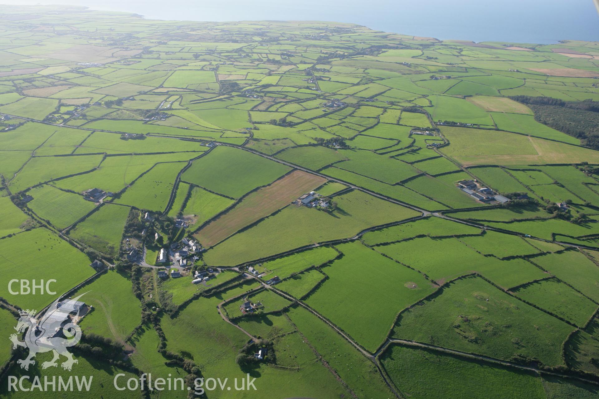 RCAHMW colour oblique aerial photograph of Bryncroes village in high landscape view. Taken on 06 September 2007 by Toby Driver