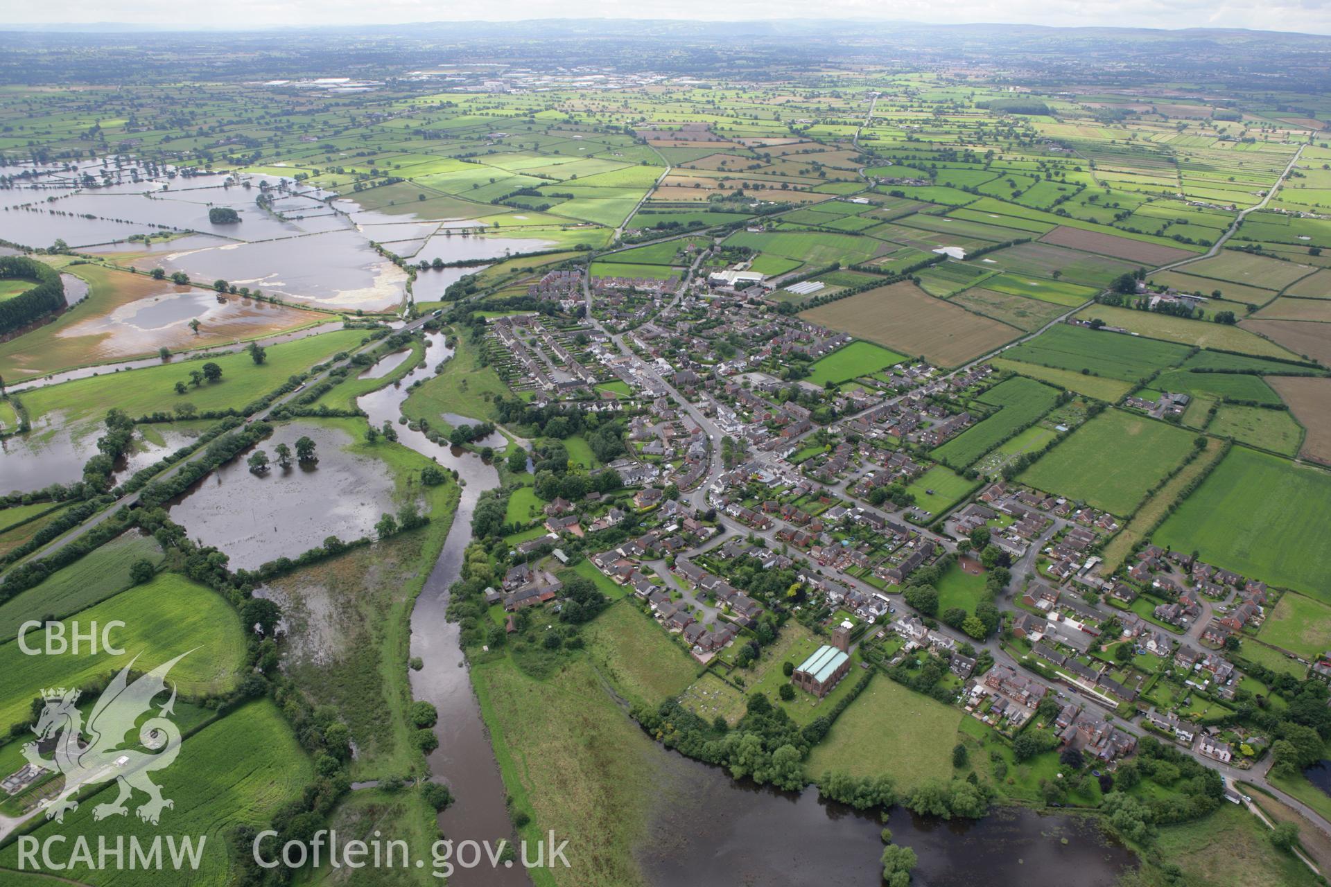 RCAHMW colour oblique aerial photograph of St Chad's Church, Holt, showing flooding from River Dee. Taken on 24 July 2007 by Toby Driver