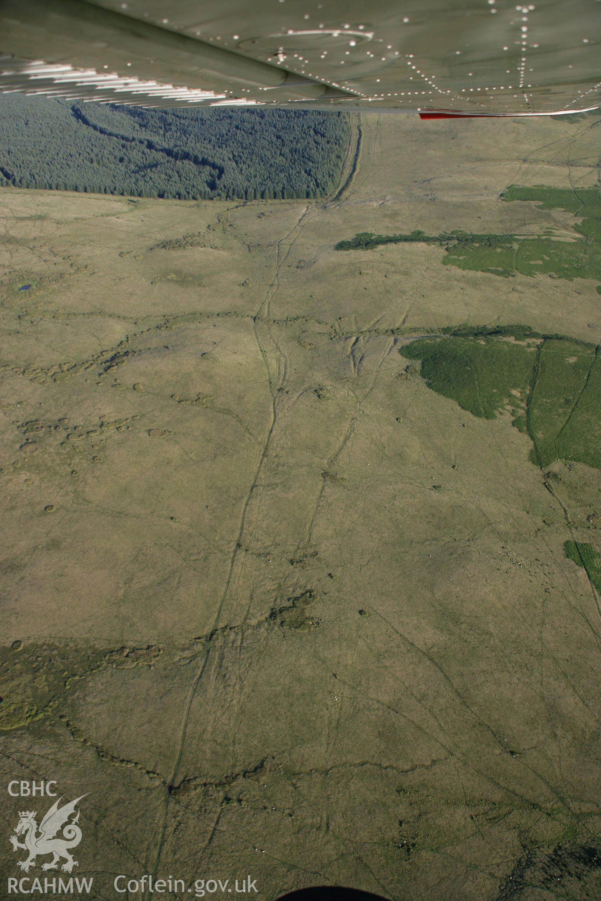 RCAHMW colour oblique aerial photograph of Cornelau Uchaf Enclosure and braided trackways, Cefn Clawdd. Taken on 08 August 2007 by Toby Driver