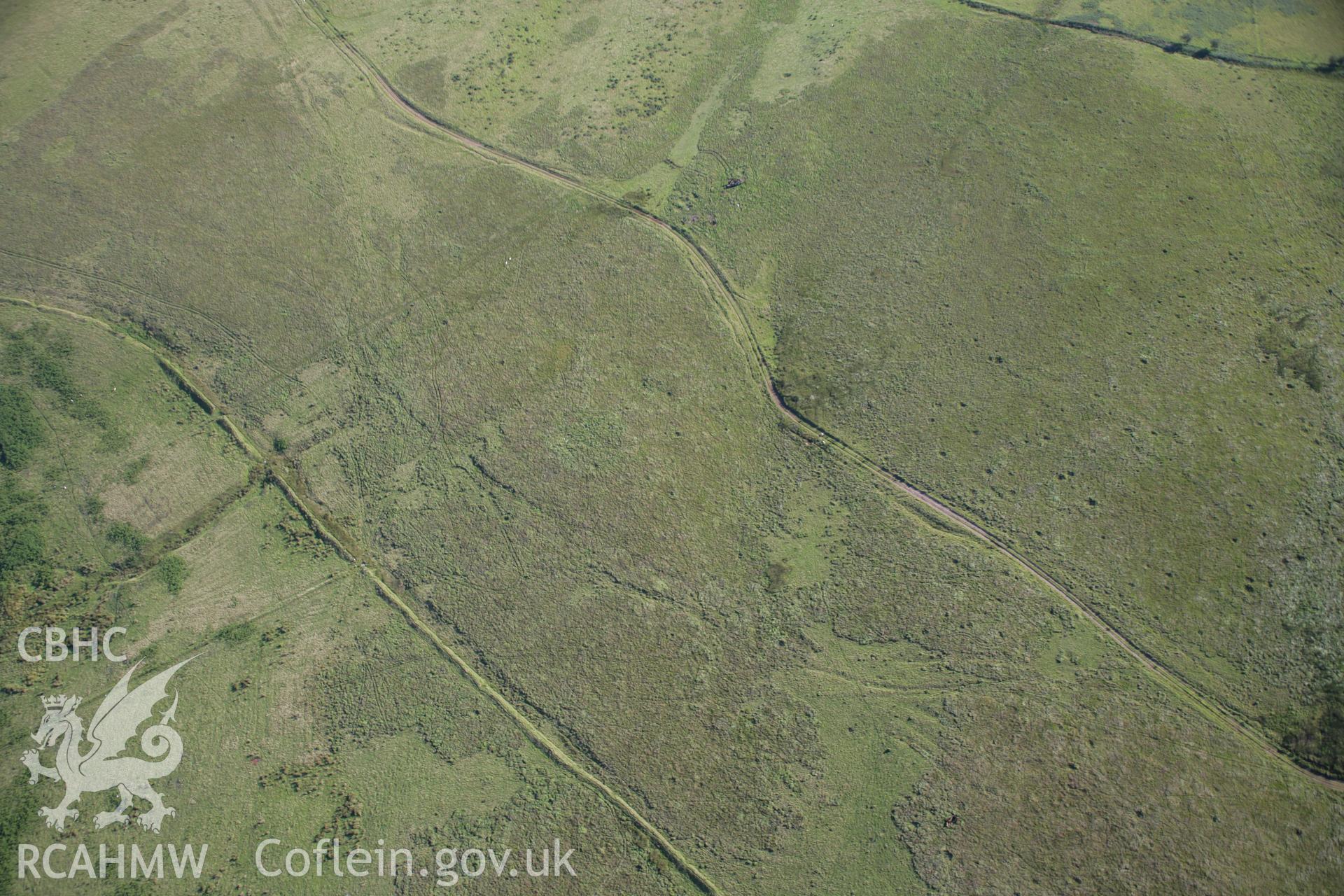 RCAHMW colour oblique aerial photograph of a stone circle and cairn west of Ynyshir. Taken on 08 August 2007 by Toby Driver